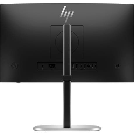 Parte trasera de un monitor de computadora negro con soporte y puertos plateados.
