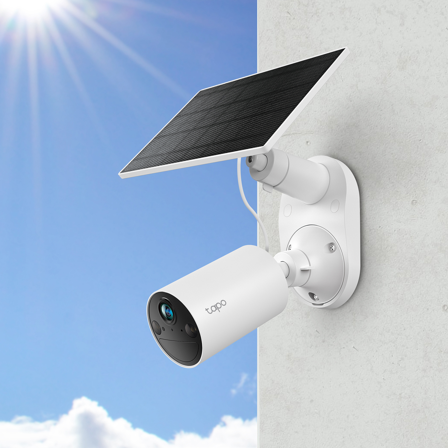 Una telecamera di sicurezza bianca con un pannello solare attaccato al lato di un edificio, sotto la luce del sole.