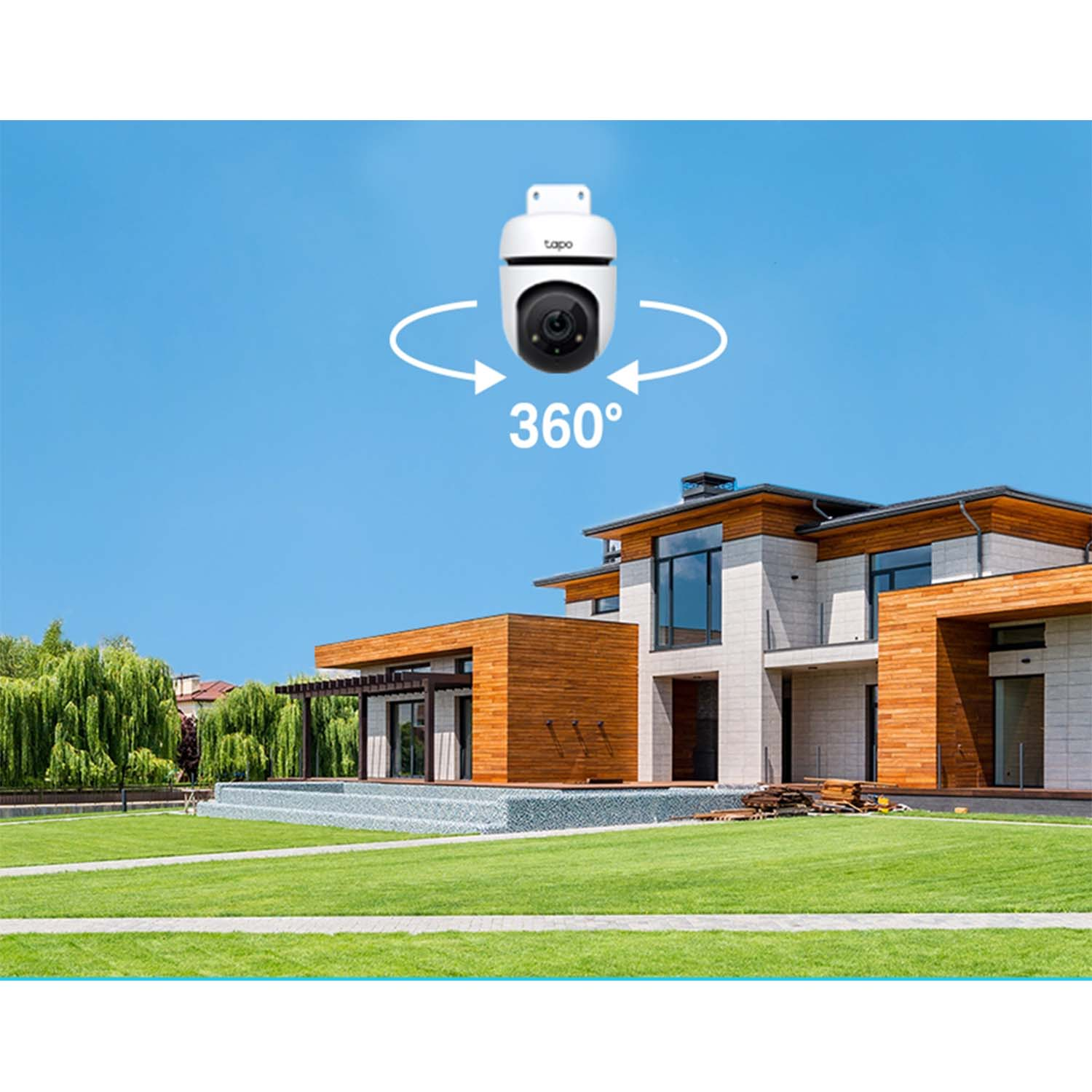 Telecamera di sicurezza bianca con vista a 360°, casa e cielo blu sullo sfondo.