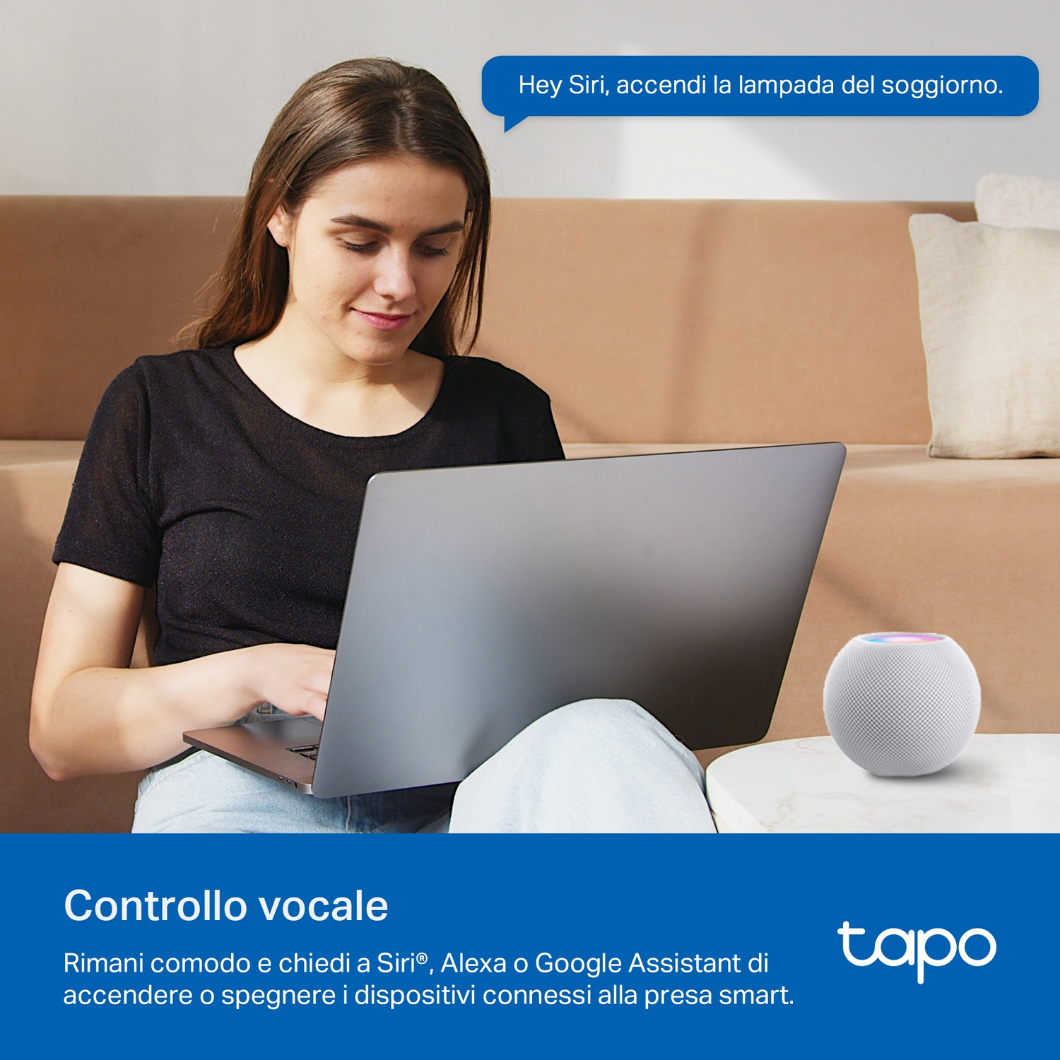 Donna con laptop usa comando vocale per controllare dispositivo smart home, con smart speaker bianco sul tavolo.