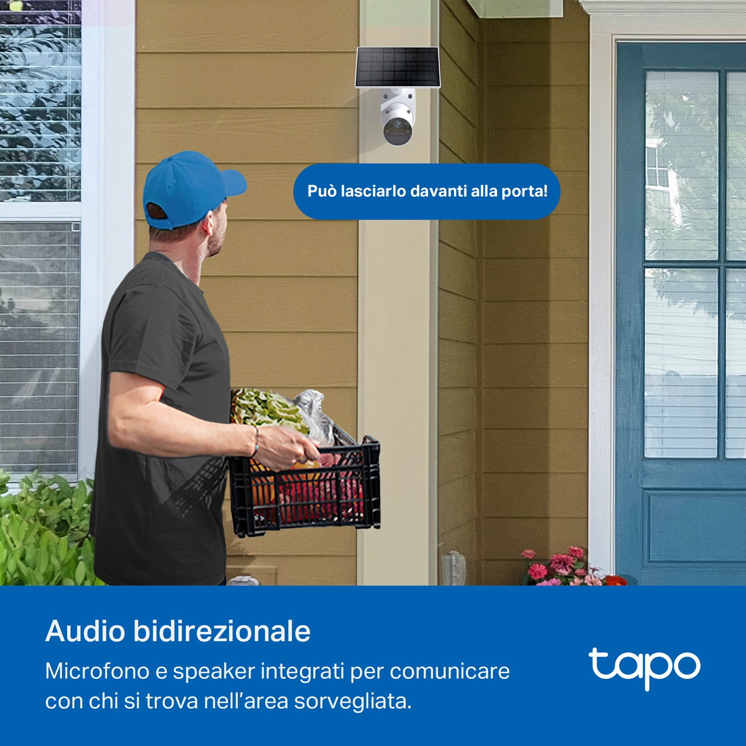 Un uomo con la spesa guarda una telecamera di sicurezza. La telecamera ha un pannello solare ed è montata sul muro.