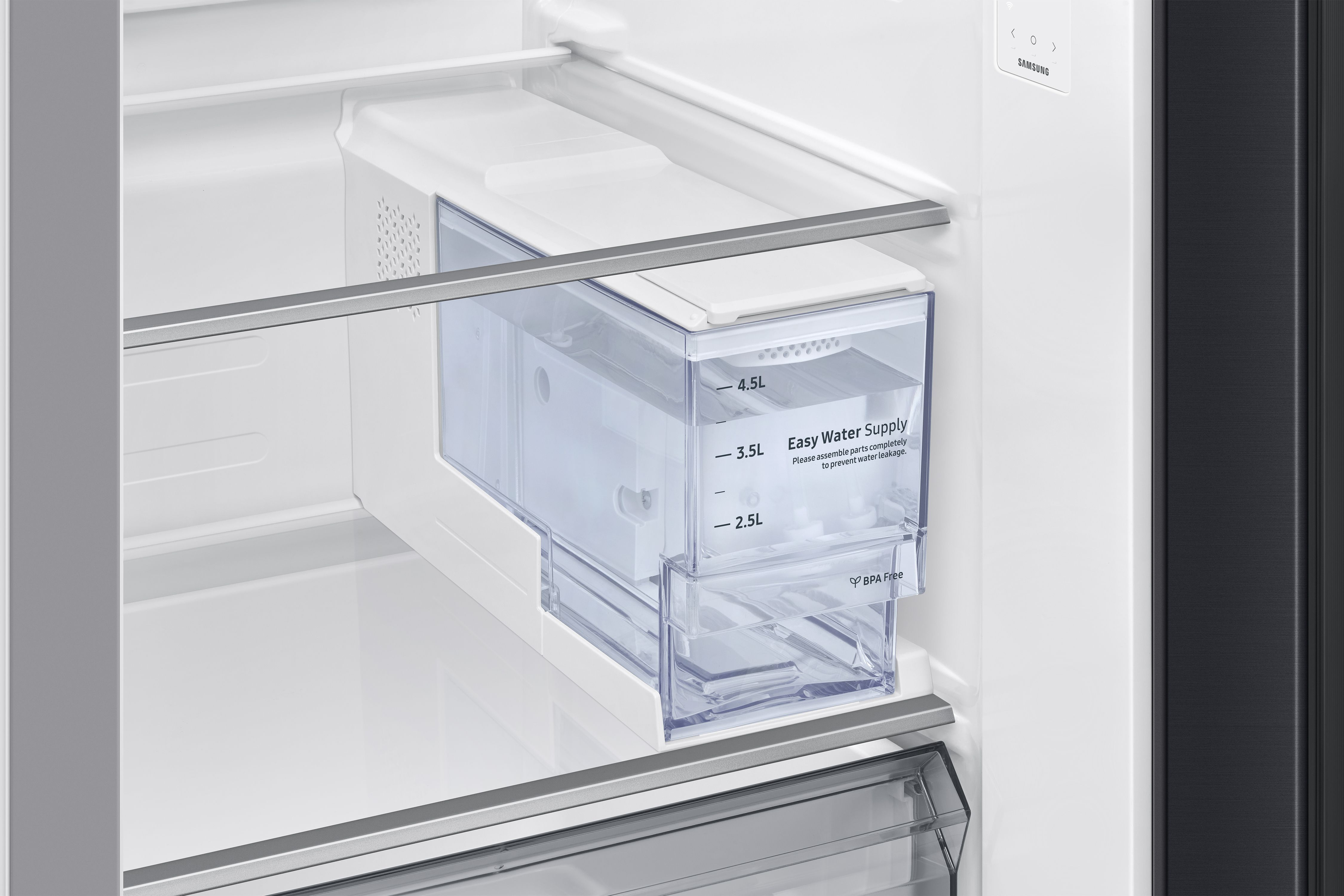 In einem weißen Kühlschrank ist ein klarer Wassertank mit Volumenmarkierungen sichtbar.