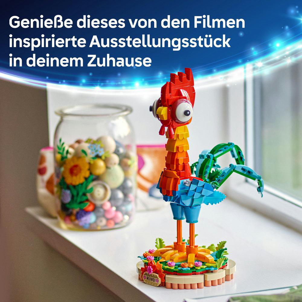 Eine bunte Lego-Figur in einem Glas auf einer Fensterbank. Die Figur ist rot, orange und blau.