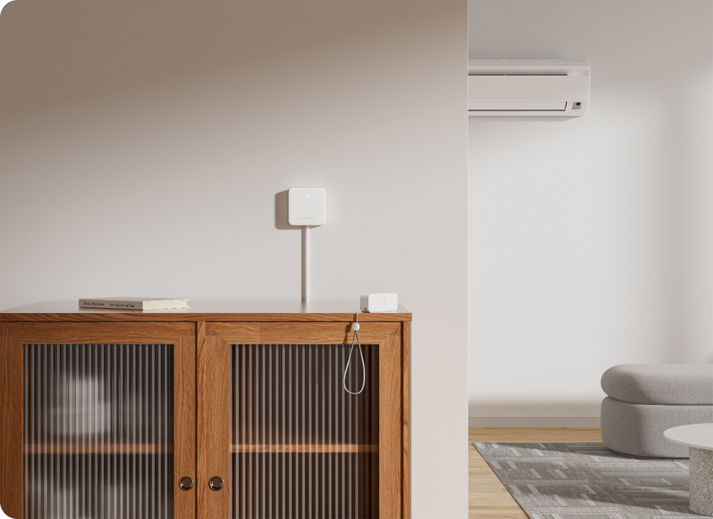 Eine Wand mit einem kleinen weißen Gerät und einem Holzschrank mit Büchern und Dekorationen. Klimaanlage oben.