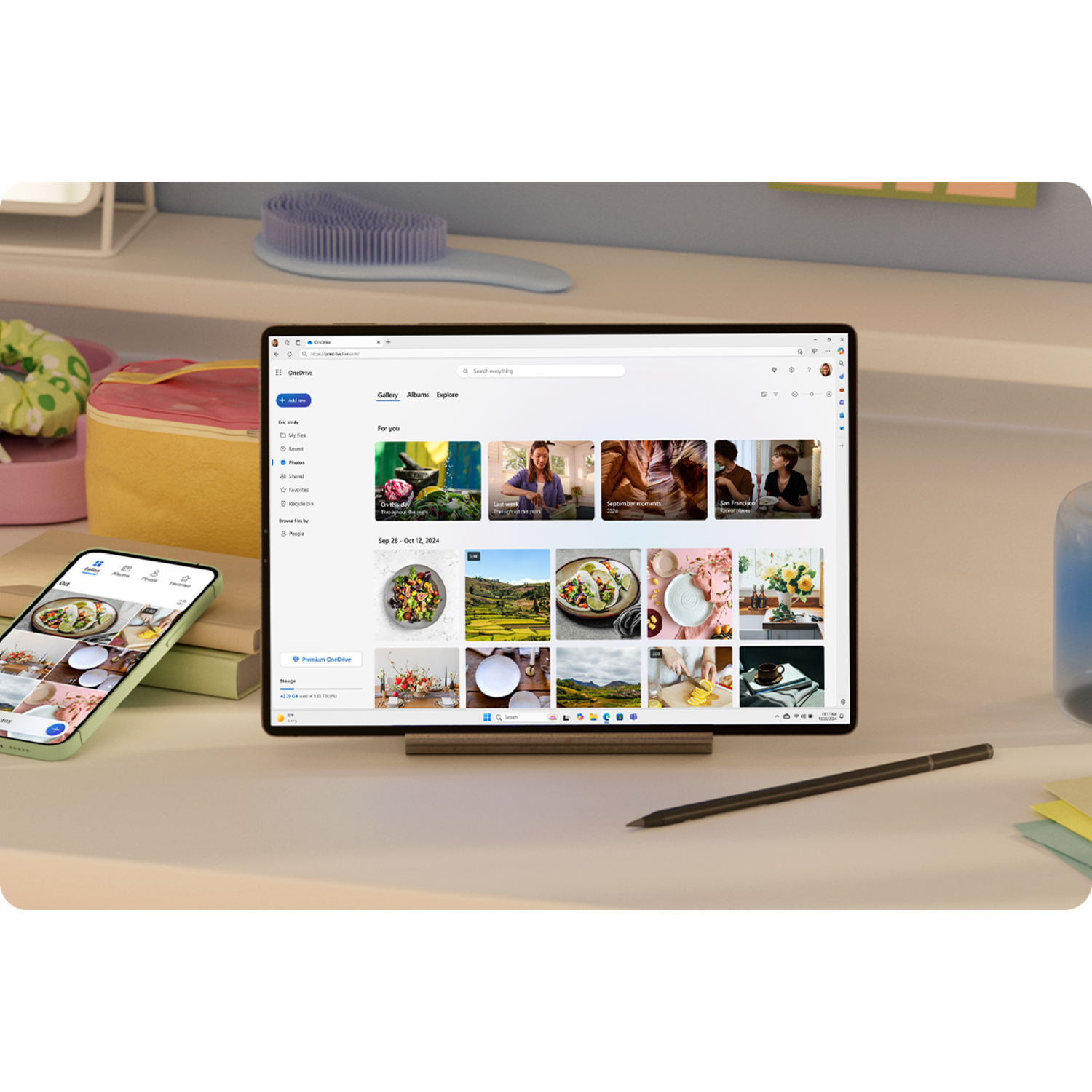 A tablet and a phone on a desk displaying a webpage and a pen. A cloud icon is also present.