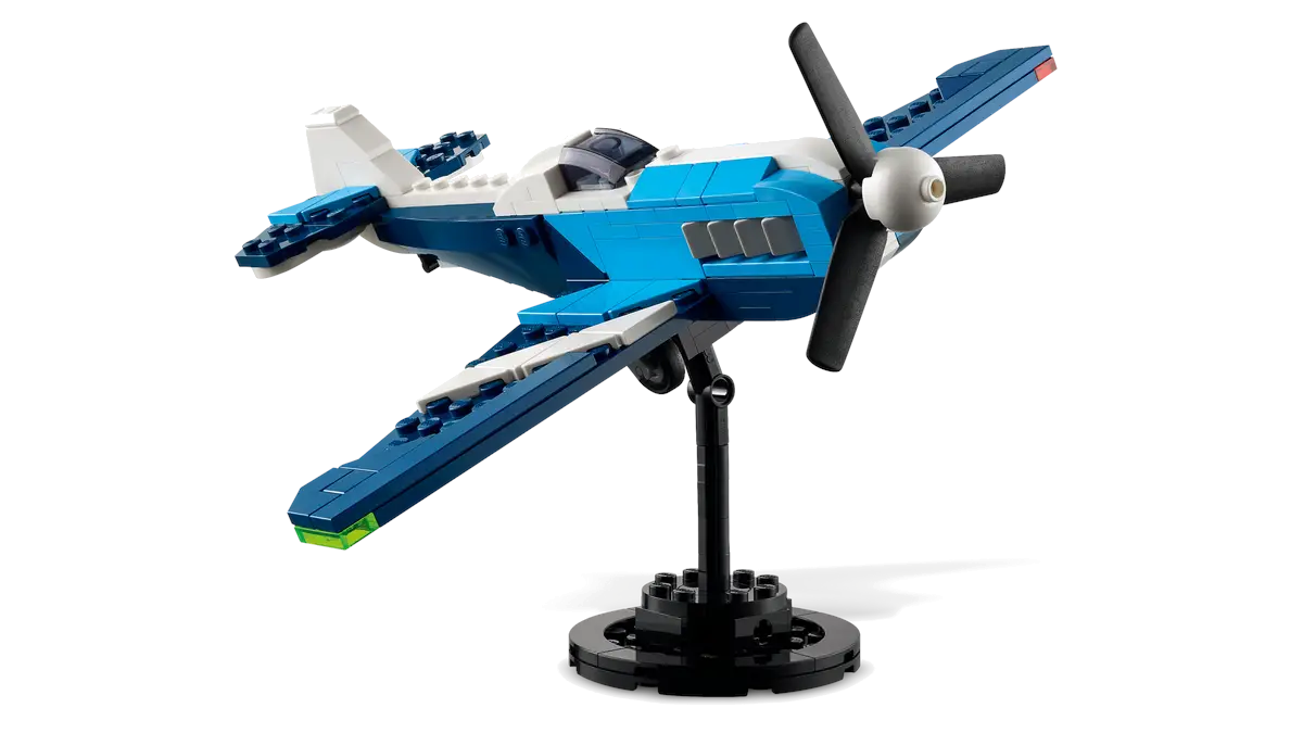 Niebiesko-biały model samolotu Lego zamontowany na stojaku na białym tle.