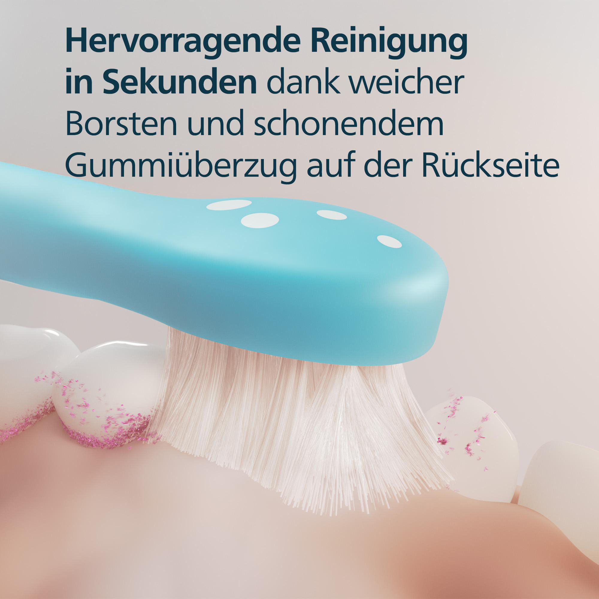 Nahaufnahme einer Zahnbürste, die Zähne putzt. Blauer Griff, weiße Borsten, rosa Partikel.