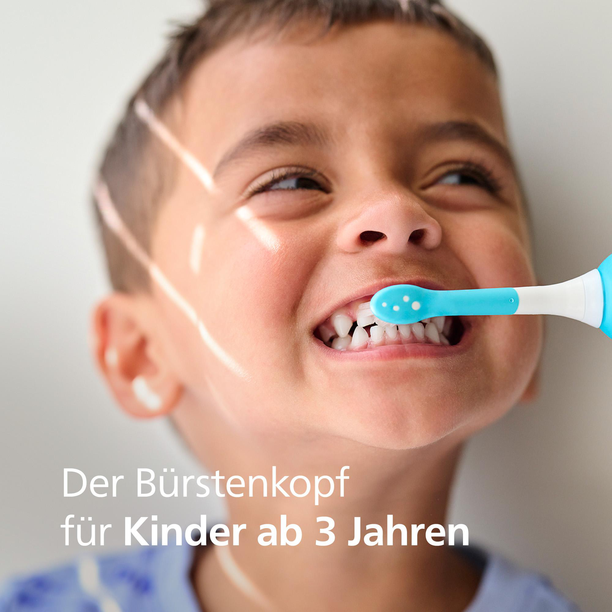 Ein kleiner Junge putzt sich die Zähne mit einer blau-weißen Zahnbürste. Text: 'Der Bürstenkopf für Kinder ab 3 Jahren'.