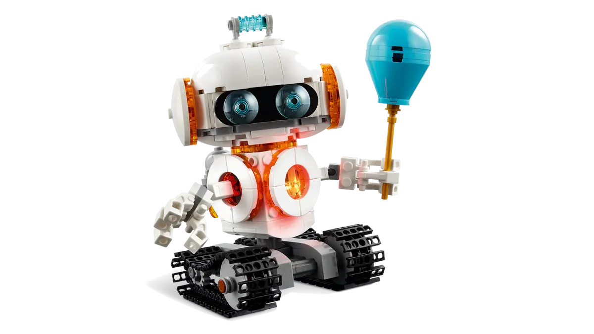 Biały robot Lego z pomarańczowymi akcentami, trzymający niebieski balon.
