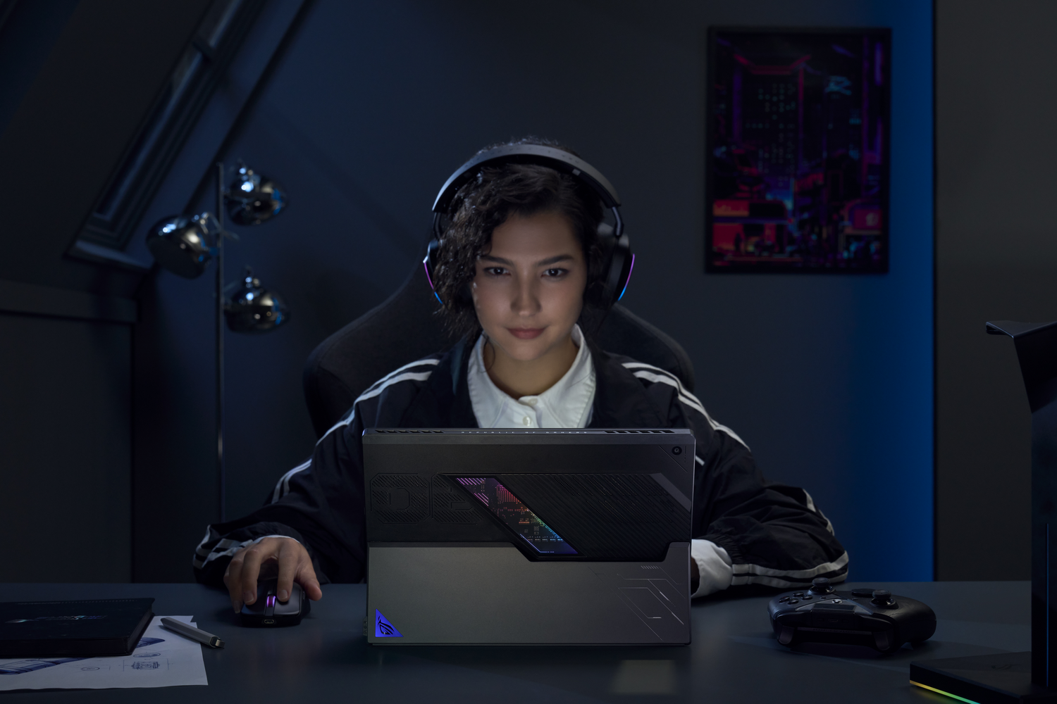 Mujer jugando en un portátil, con auriculares. La habitación está oscura, iluminada por la pantalla y luces ambientales.