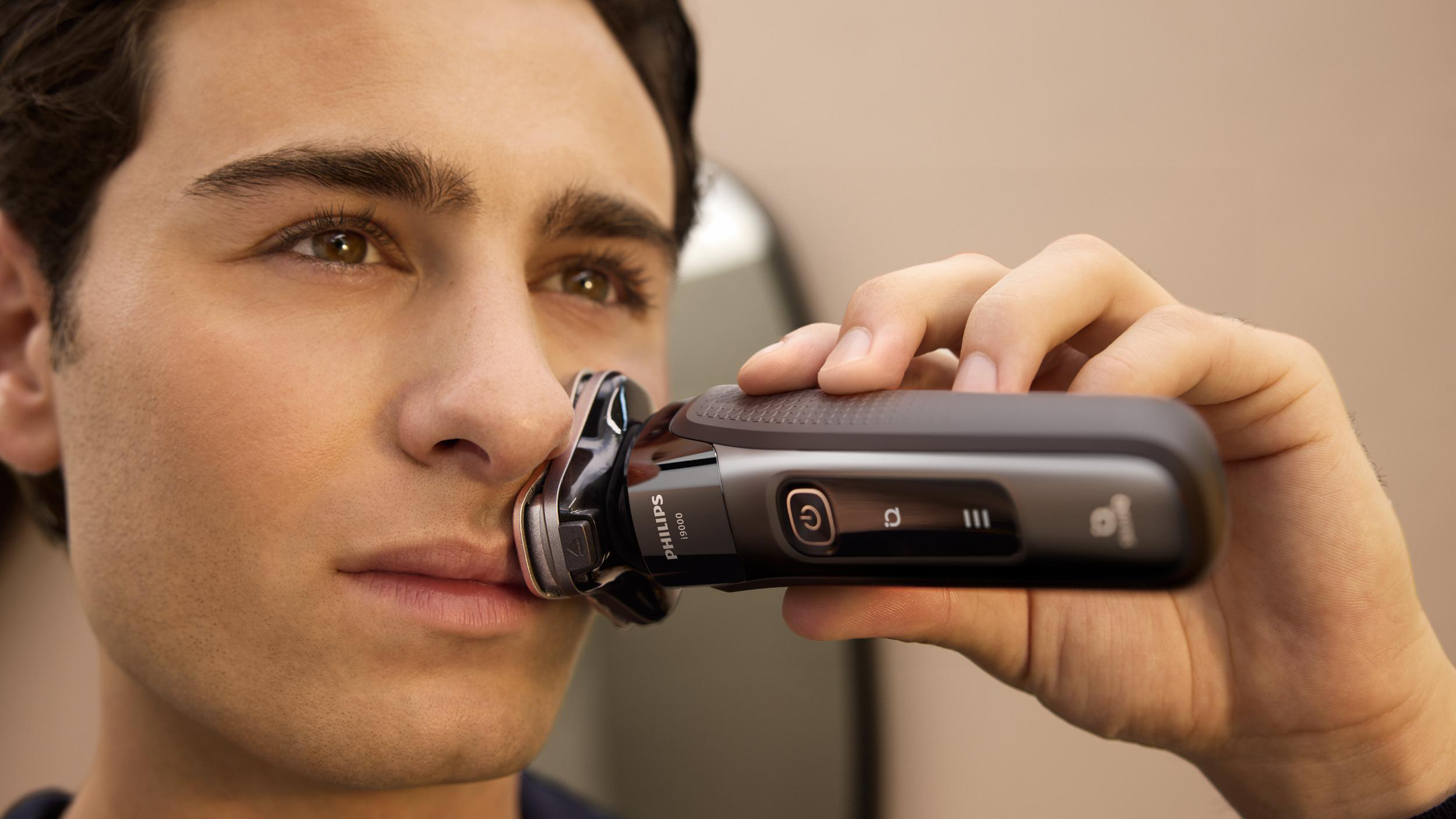Mann rasiert sich mit einem elektrischen Rasierer im Nahbereich, zeigt die Klingen.