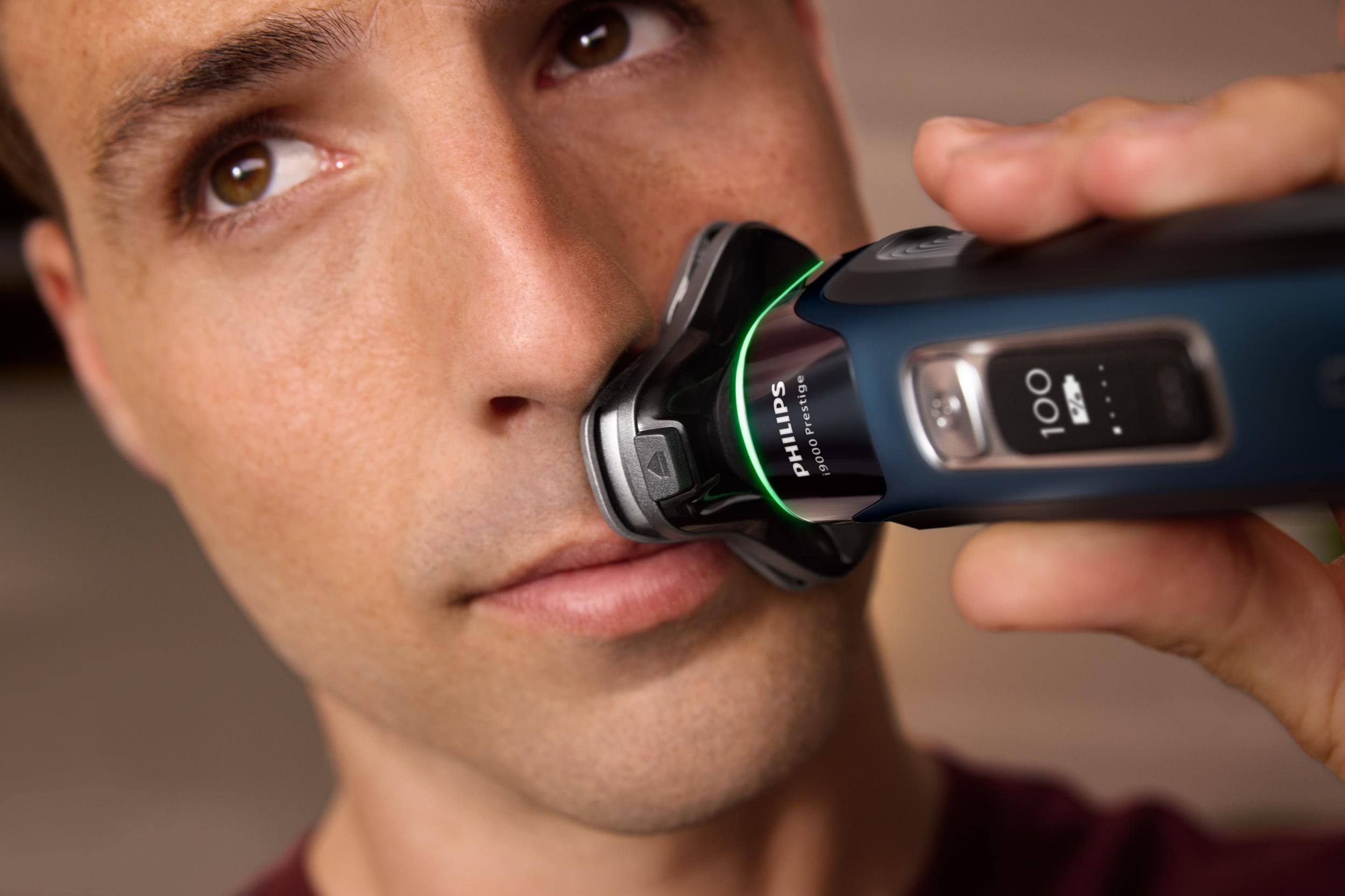 Mann rasiert sich mit einem elektrischen Rasierer, Nahaufnahme, zeigt den Rasiererkopf.