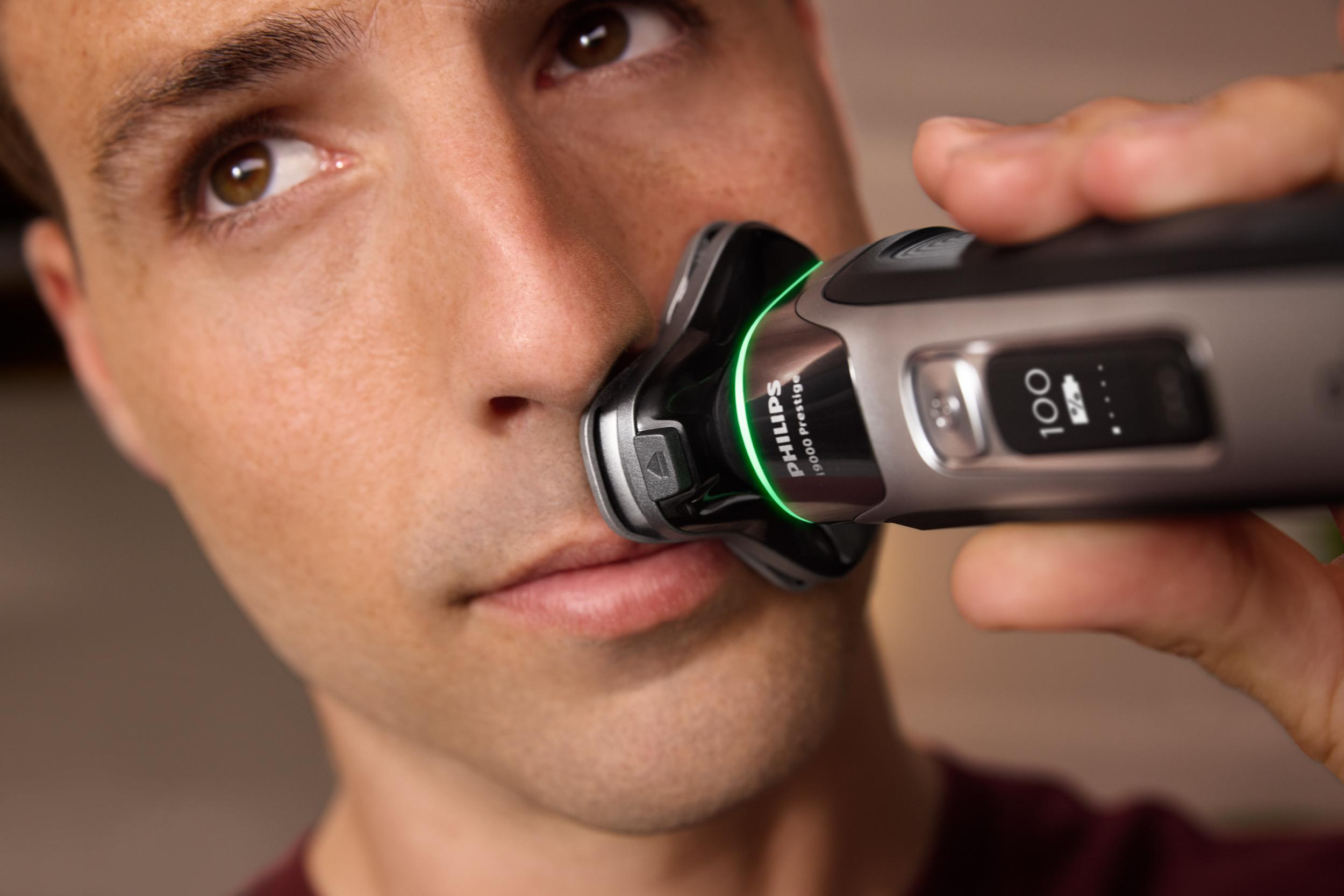 Mann rasiert sich mit einem Philips-Rasierer, Nahaufnahme.