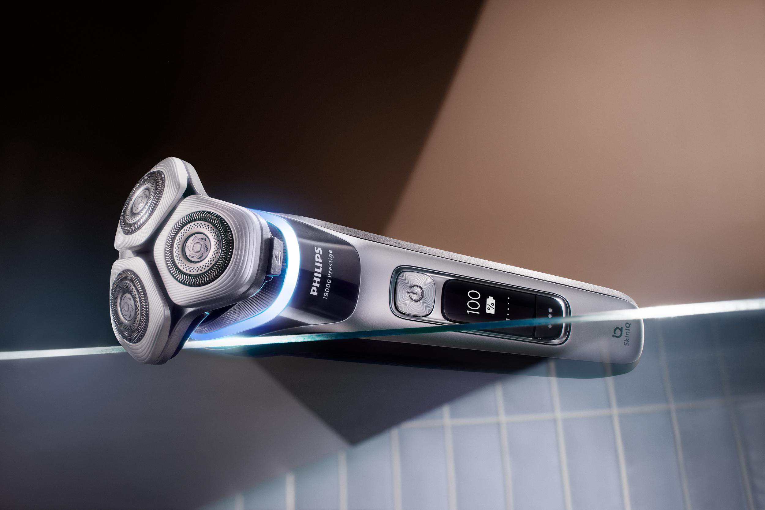 Elektrischer Rasierer mit drei rotierenden Köpfen und Digitalanzeige.