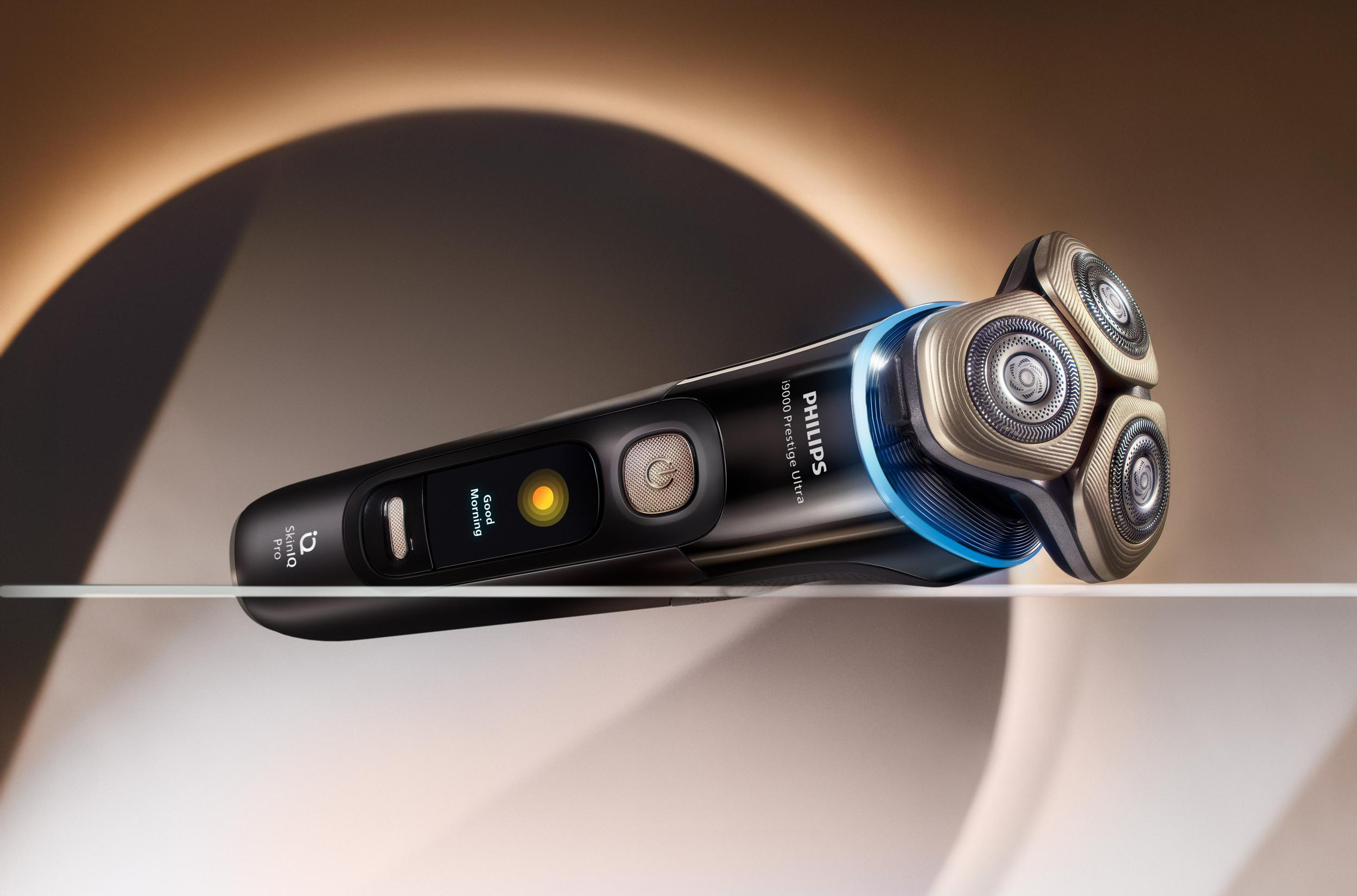 Schwarzer Philips-Rasierer auf reflektierender Oberfläche. Blaue Lichter und goldene Rasierköpfe sind sichtbar.
