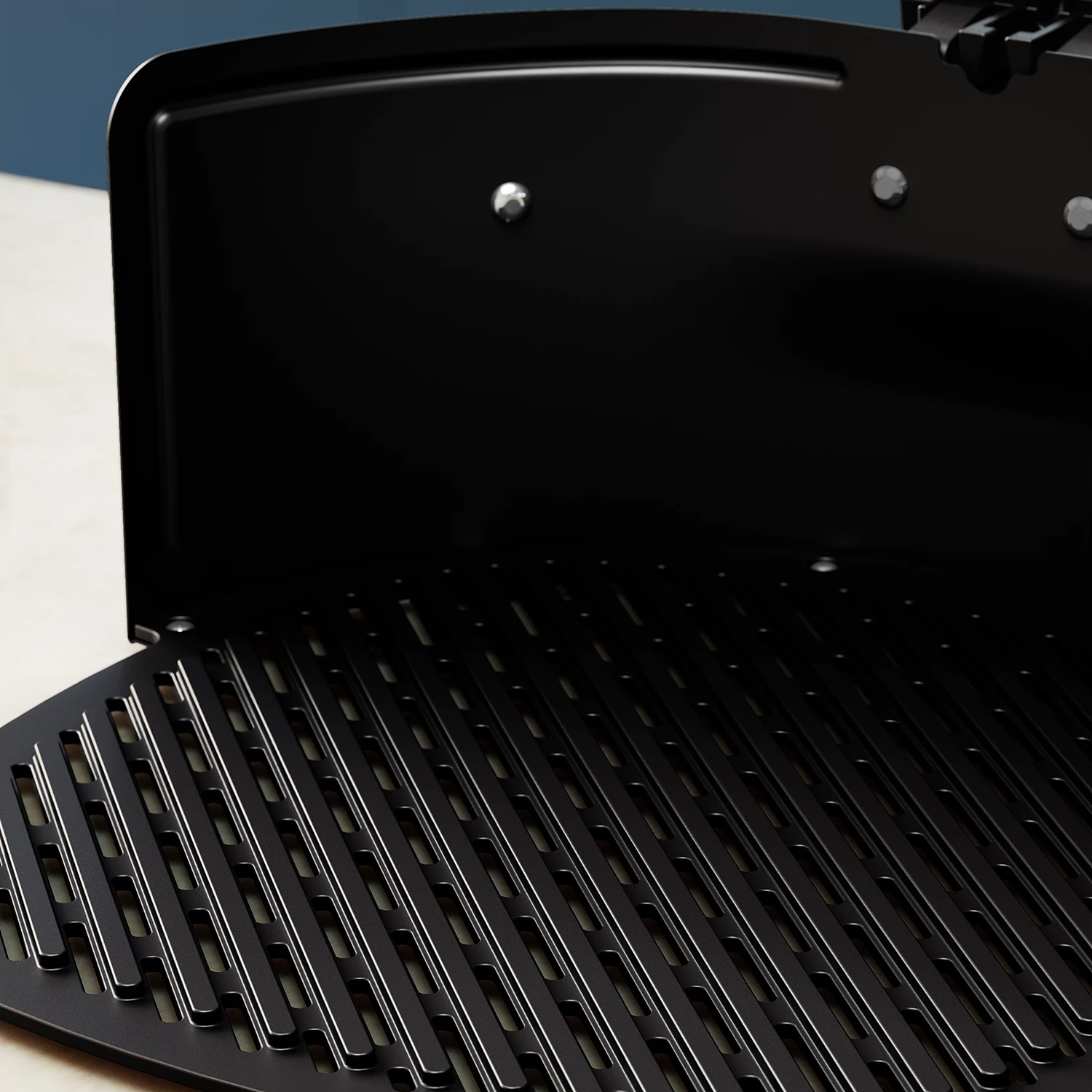 Ein offener schwarzer Grill mit Metallrost, der Details der Kochfläche zeigt.