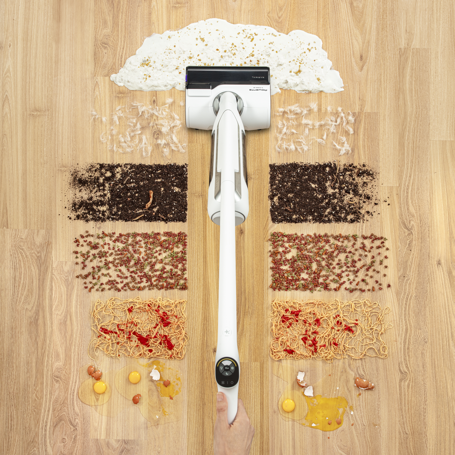 Vacuum cleaner cleaning up food items. Spaghetti, eggs, and other debris on wood floor.