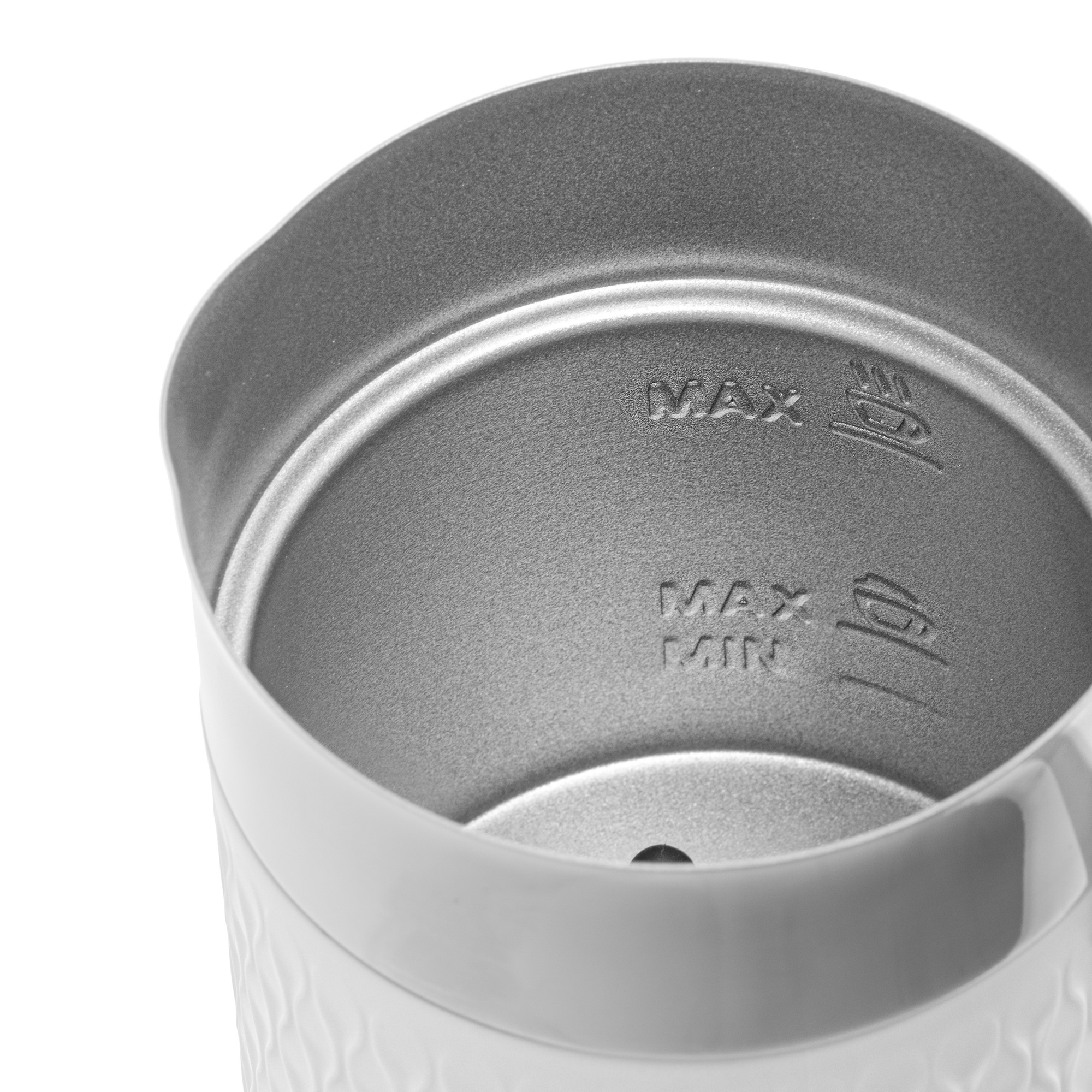 Közelkép egy fehér habosító kancsó belsejéről, 'MAX' és 'MIN' jelzésekkel. Fehér háttér.