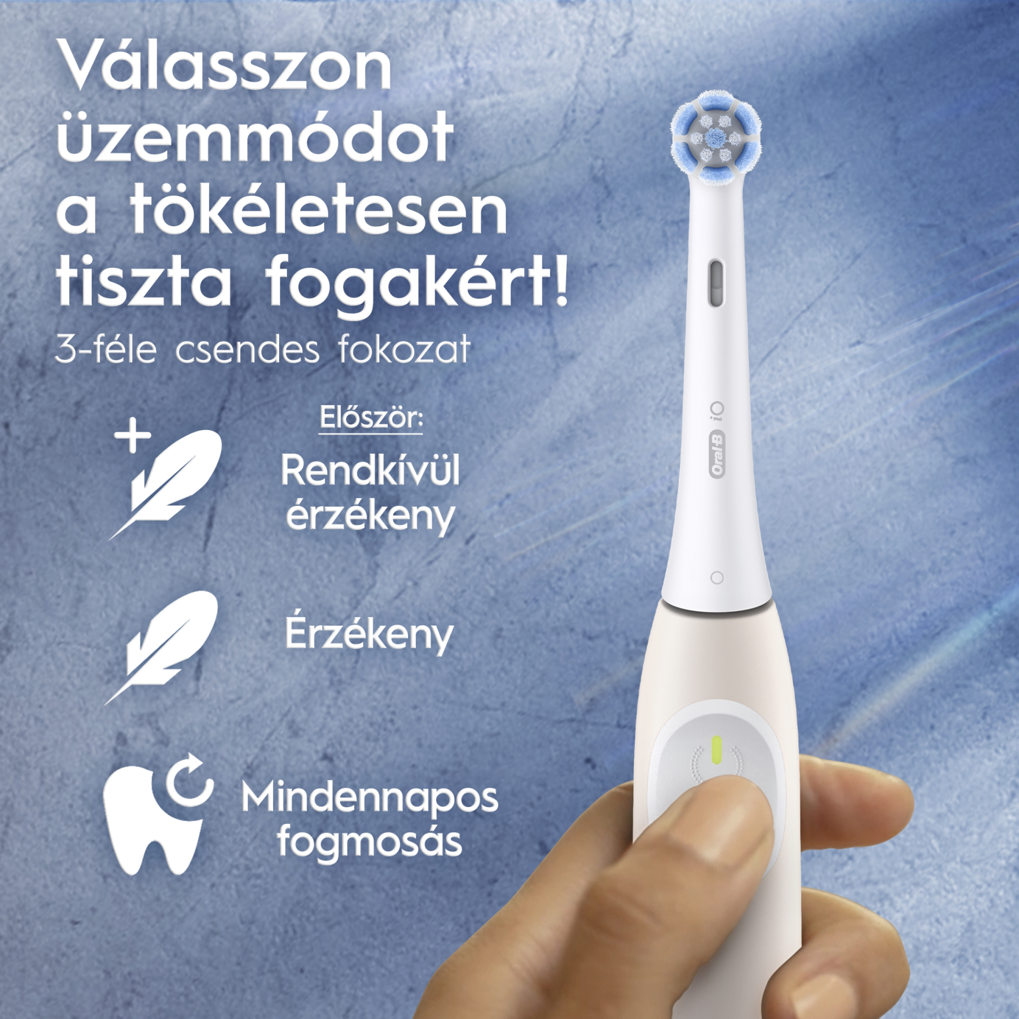 Elektromos fogkefe fehér testtel. A közelkép a kefét és a tartó kezet mutatja.