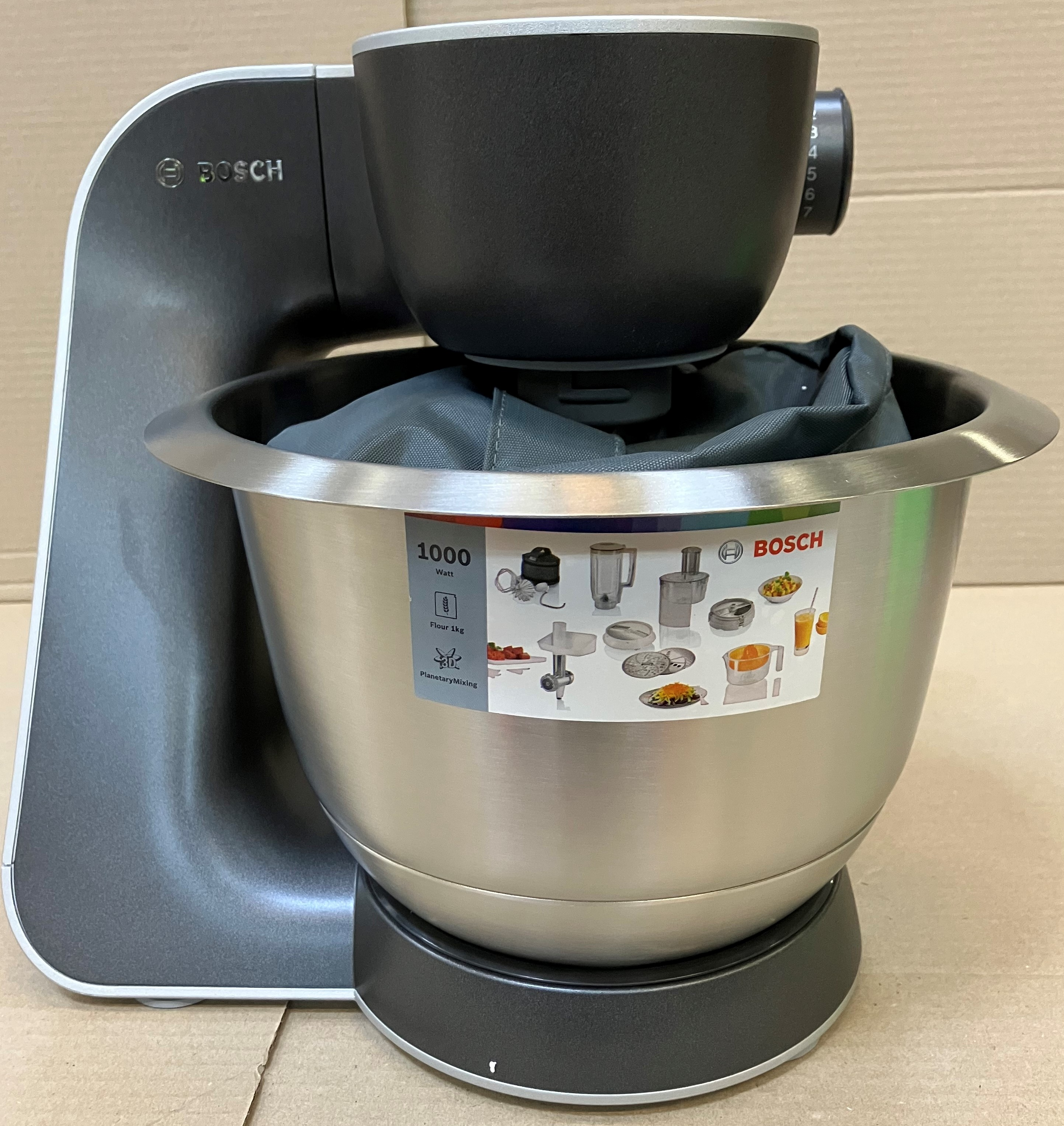 Szary i srebrny mikser kuchenny Bosch z przystawkami.