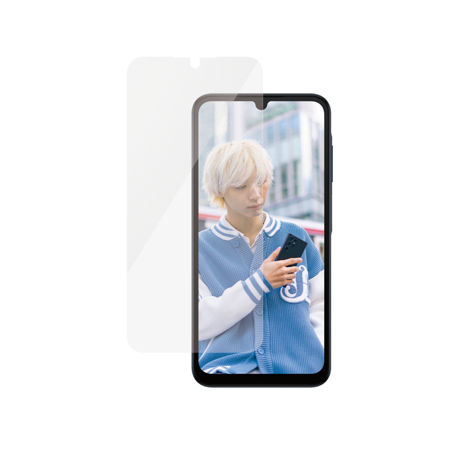 Une personne aux cheveux blonds tient un téléphone, portant une veste bleue. Un protecteur d'écran est devant le téléphone.