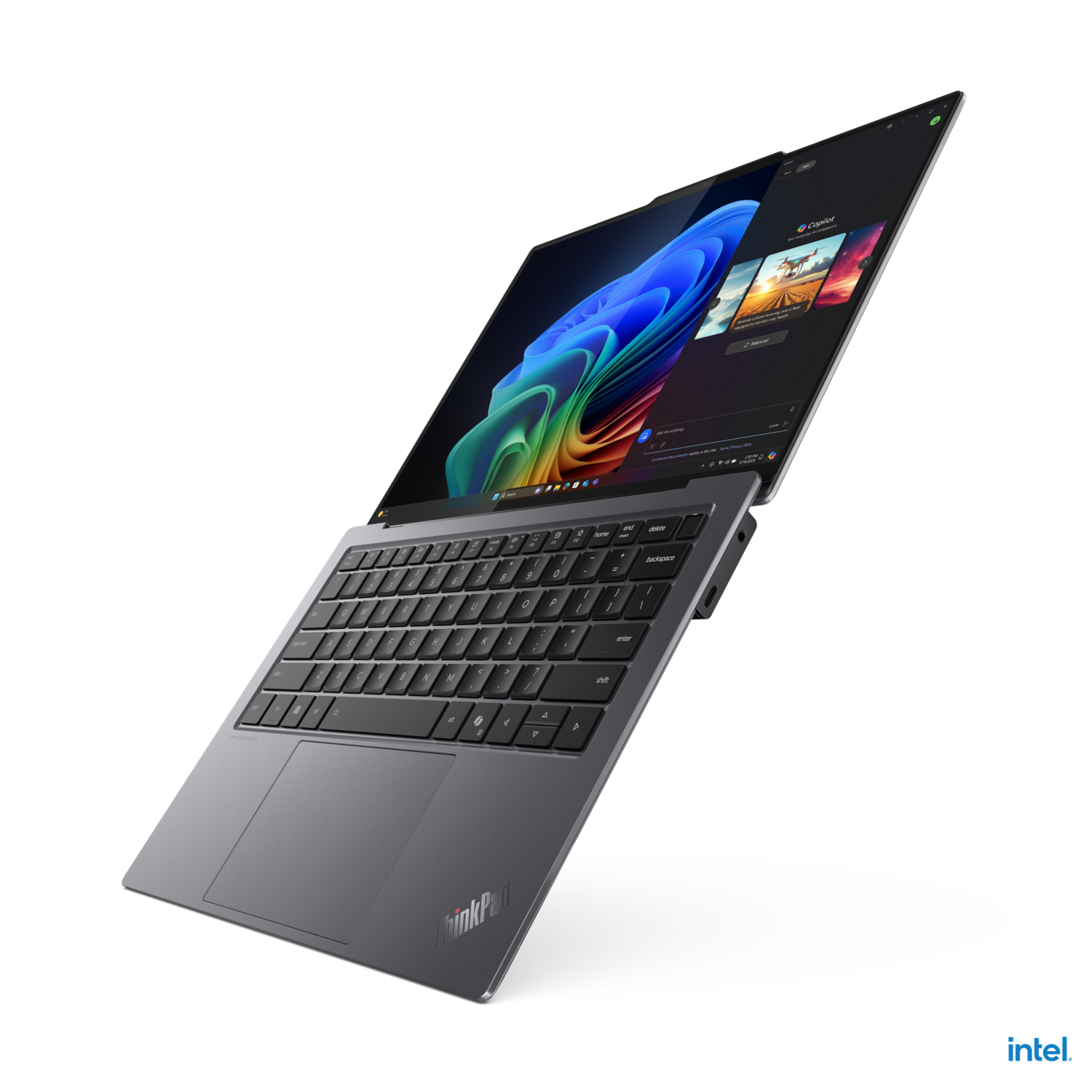 Laptop on a black background, angled view, showing keyboard and screen, partially open.