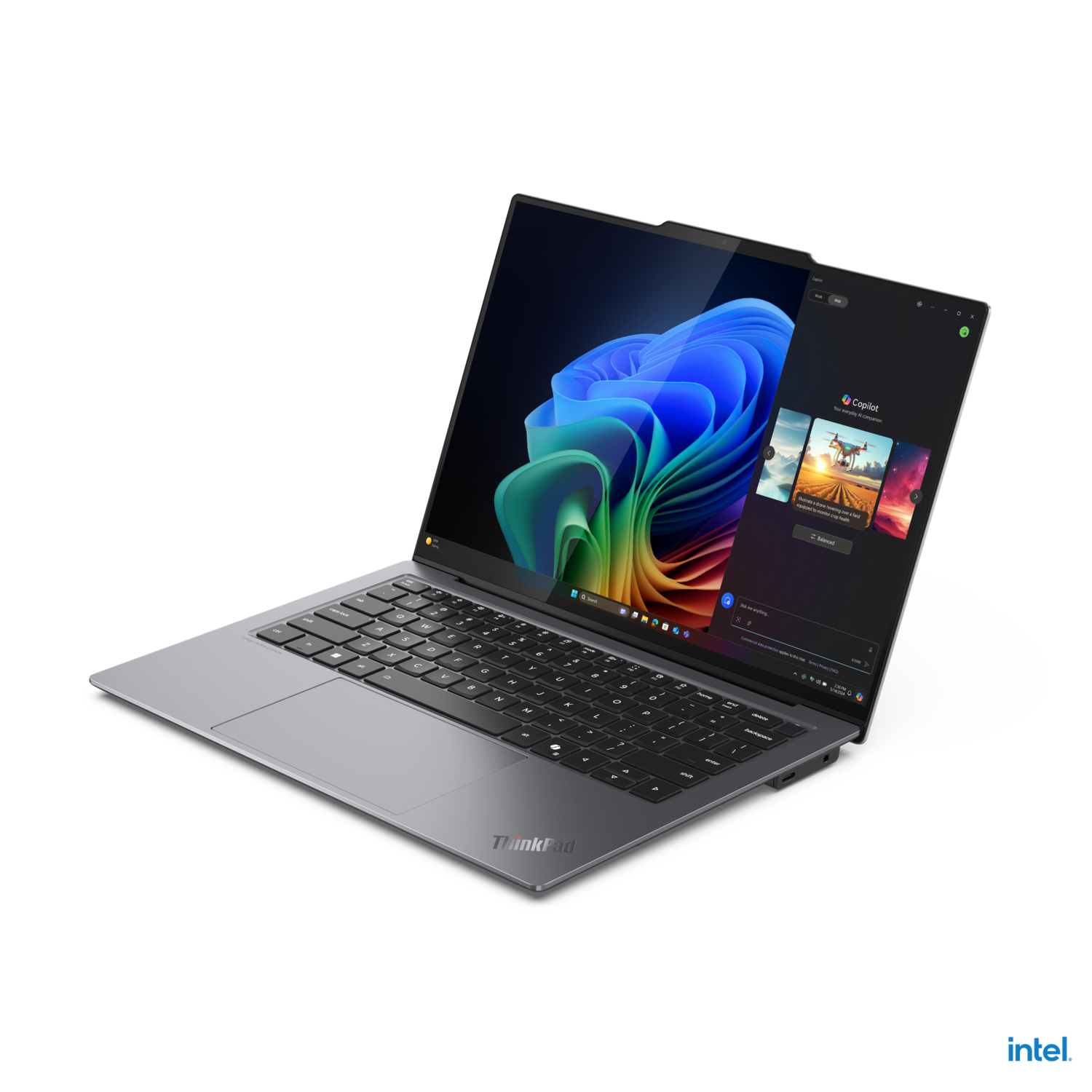A laptop displaying colorful images, angled on a black surface.