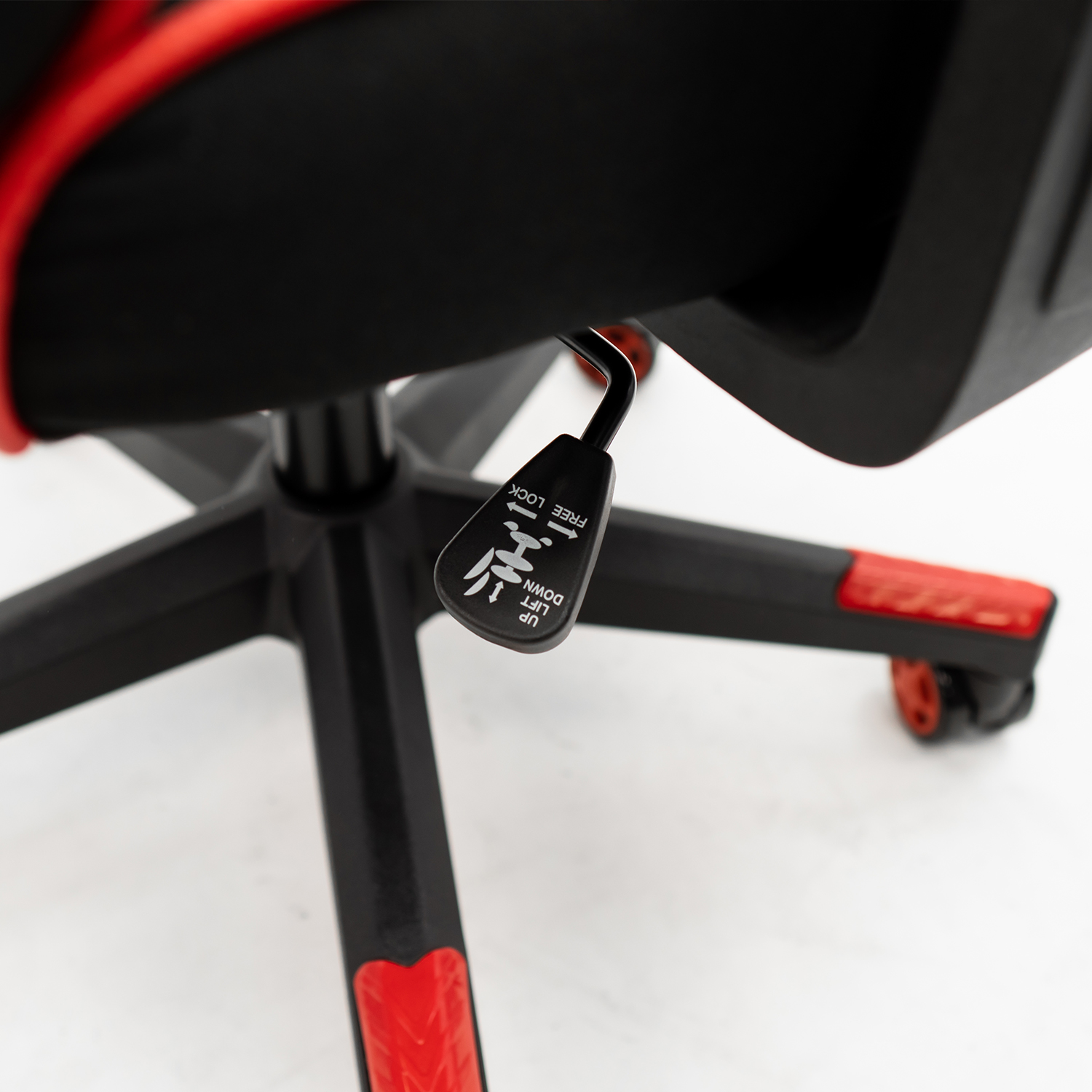 Primer plano de una silla gaming negra y roja con palanca de ajuste.