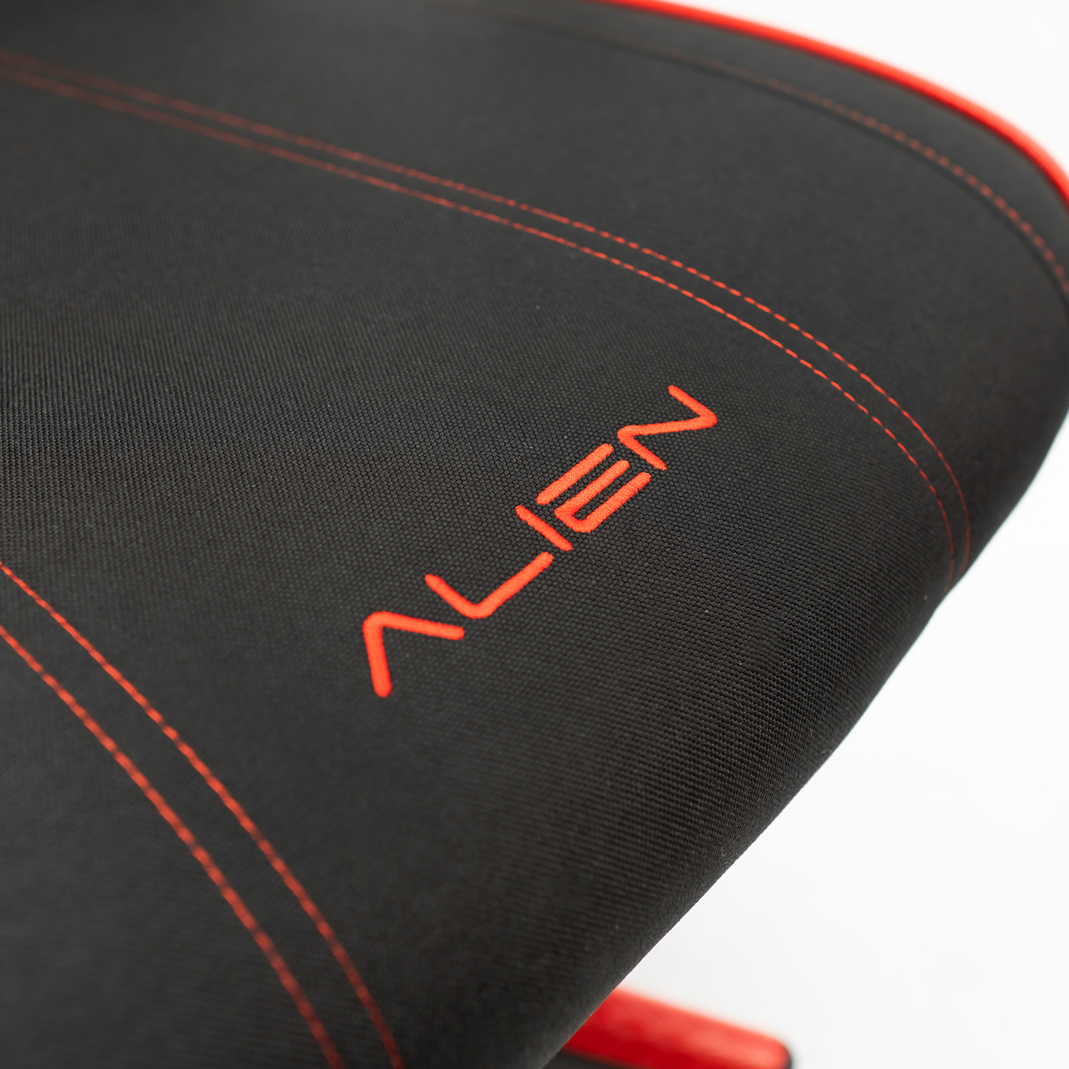 Primer plano de silla gaming negra con la palabra ALIEN en costuras rojas.
