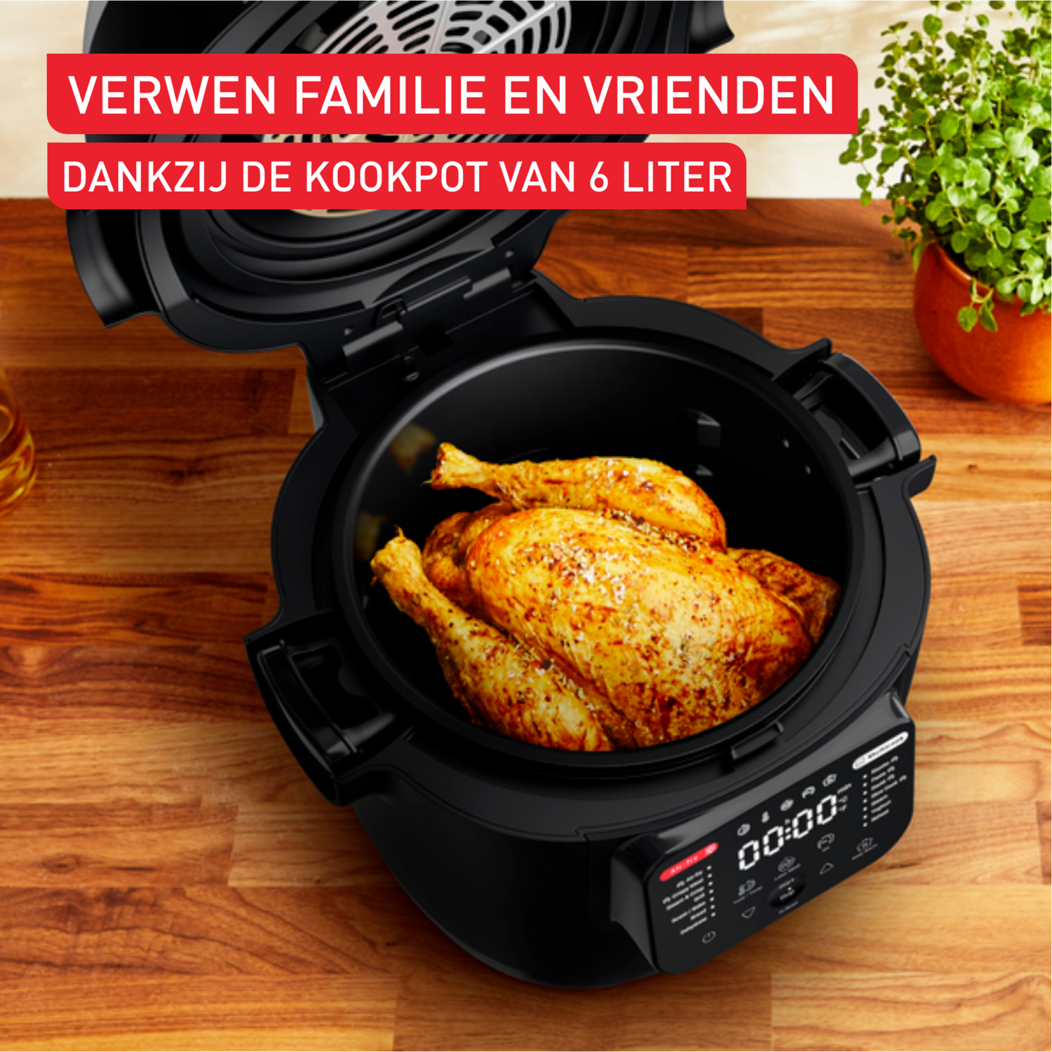 Een gebraden kip in een zwarte airfryer, op een houten tafel, met tekst erboven.