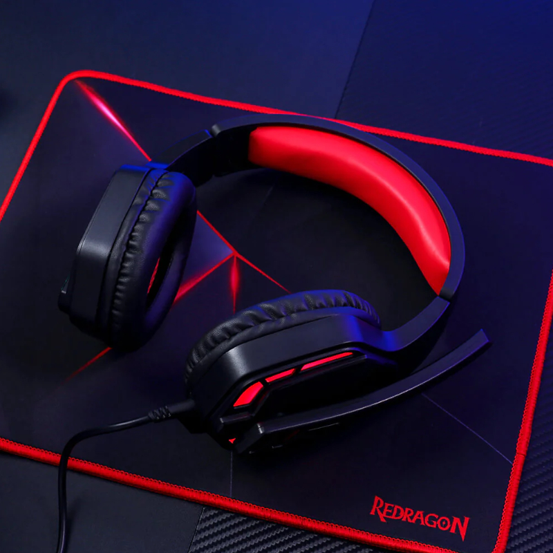 Fekete és piros gamer headset fekete és piros egérpadon. A Redragon a márka.