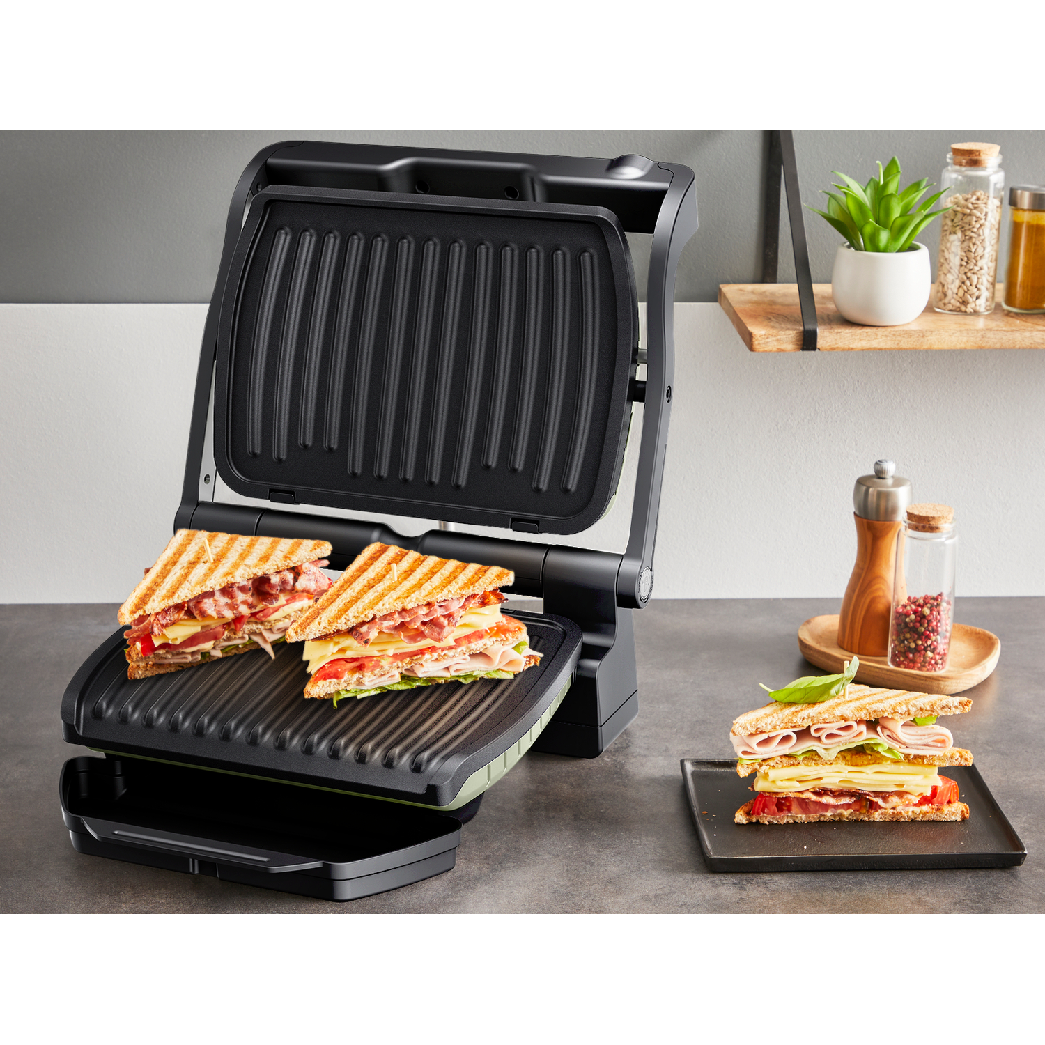 Een gesloten tosti-ijzer met twee tosti's erin en één aan de zijkant.