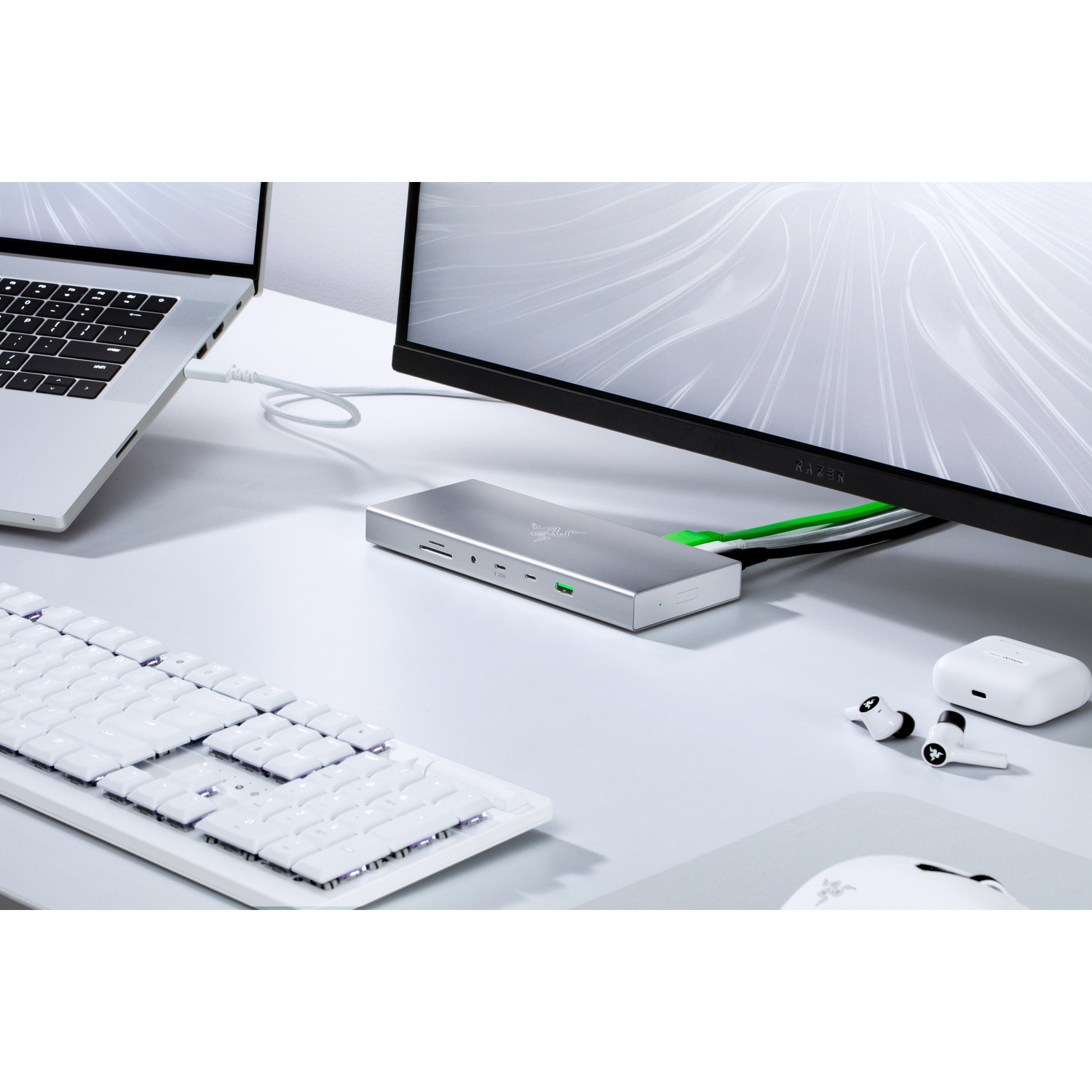 A silver hub with several ports connected to a laptop, monitor, keyboard, and accessories.