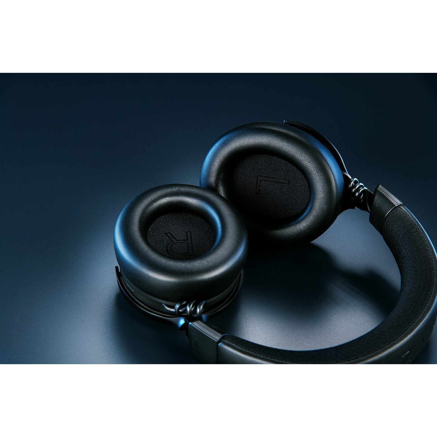 Casque noir sur une surface sombre. Les écouteurs portent les lettres 'R' et 'L'.