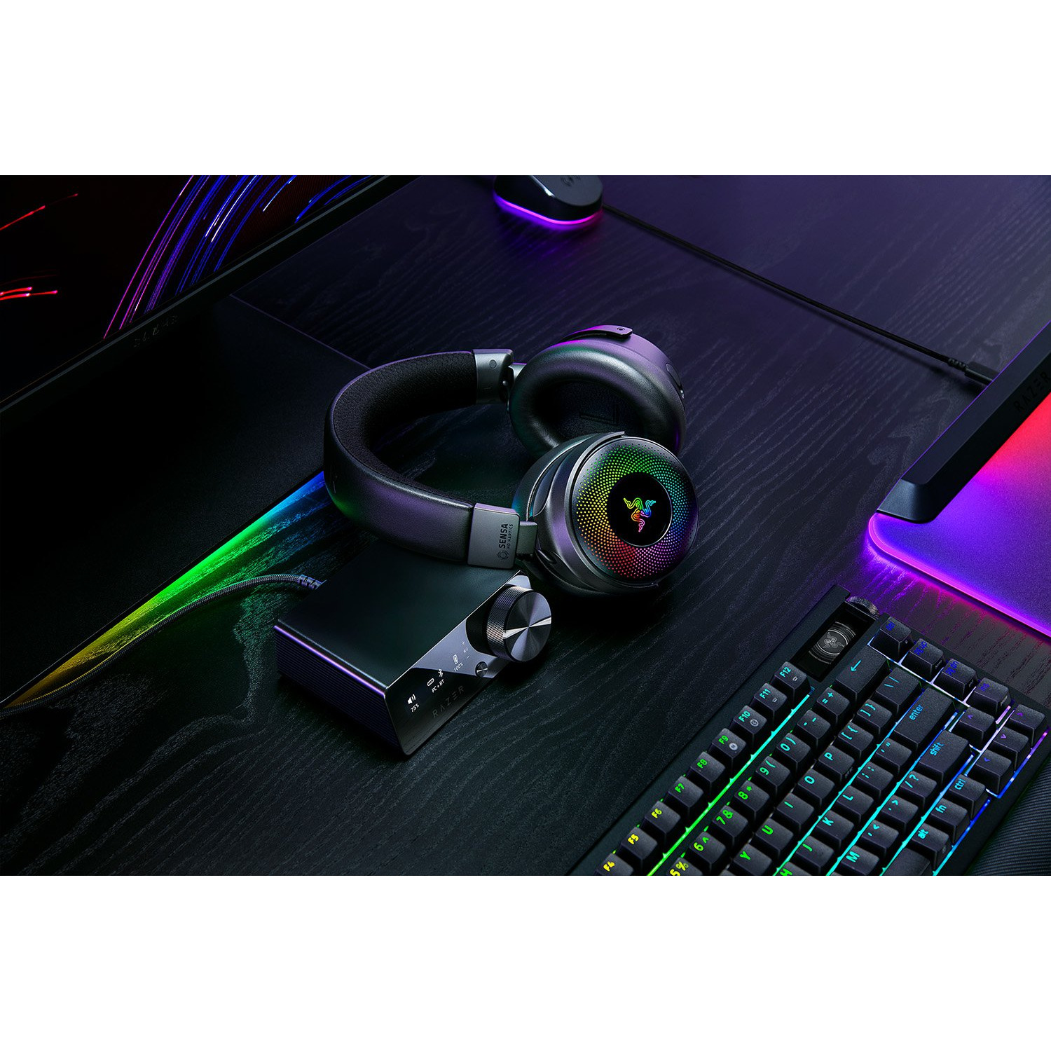 Casque audio, amplificateur et clavier avec lumières colorées sur une table noire.