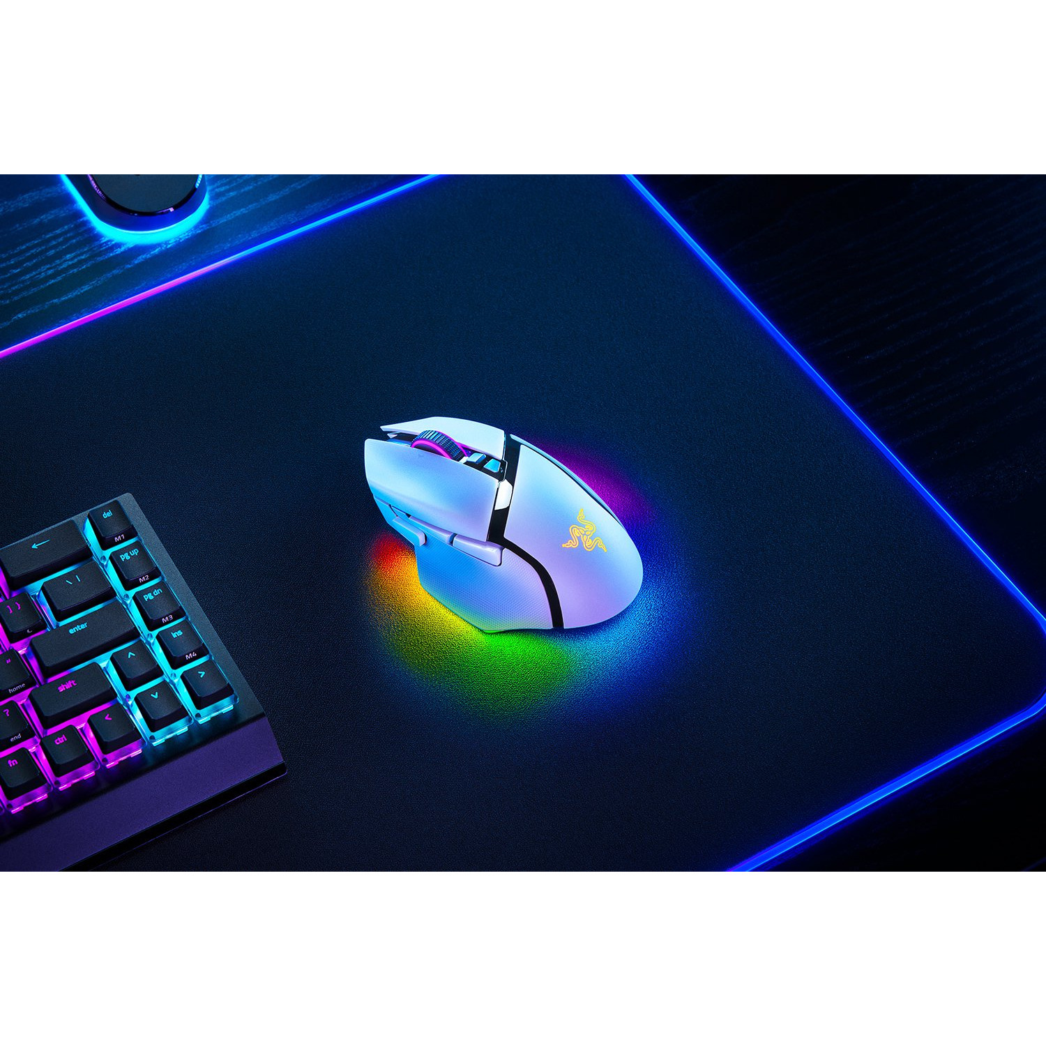 Witte gamingmuis op een zwarte muismat met kleurrijke LED-verlichting en toetsenbord.