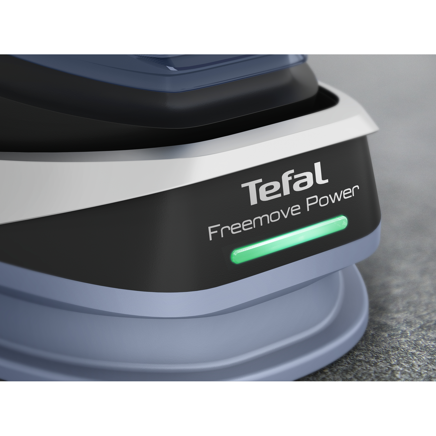 Close-up of Tefal iron with green light indicating power on; black body, blue base.