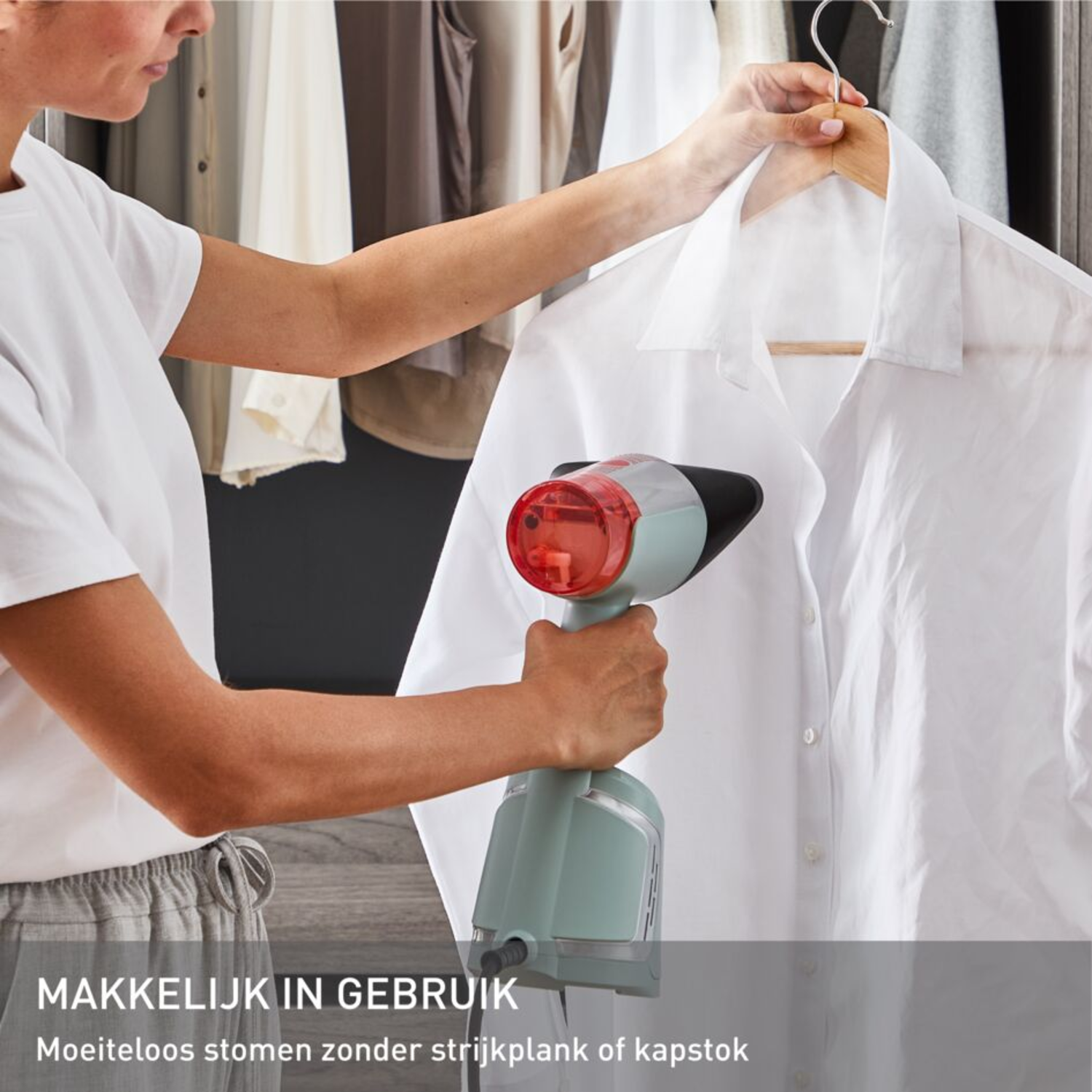 Vrouw die een wit overhemd stoomt met een handheld steamer. Tekst: 'Makkelijk in gebruik' en 'Moeiteloos stomen'.