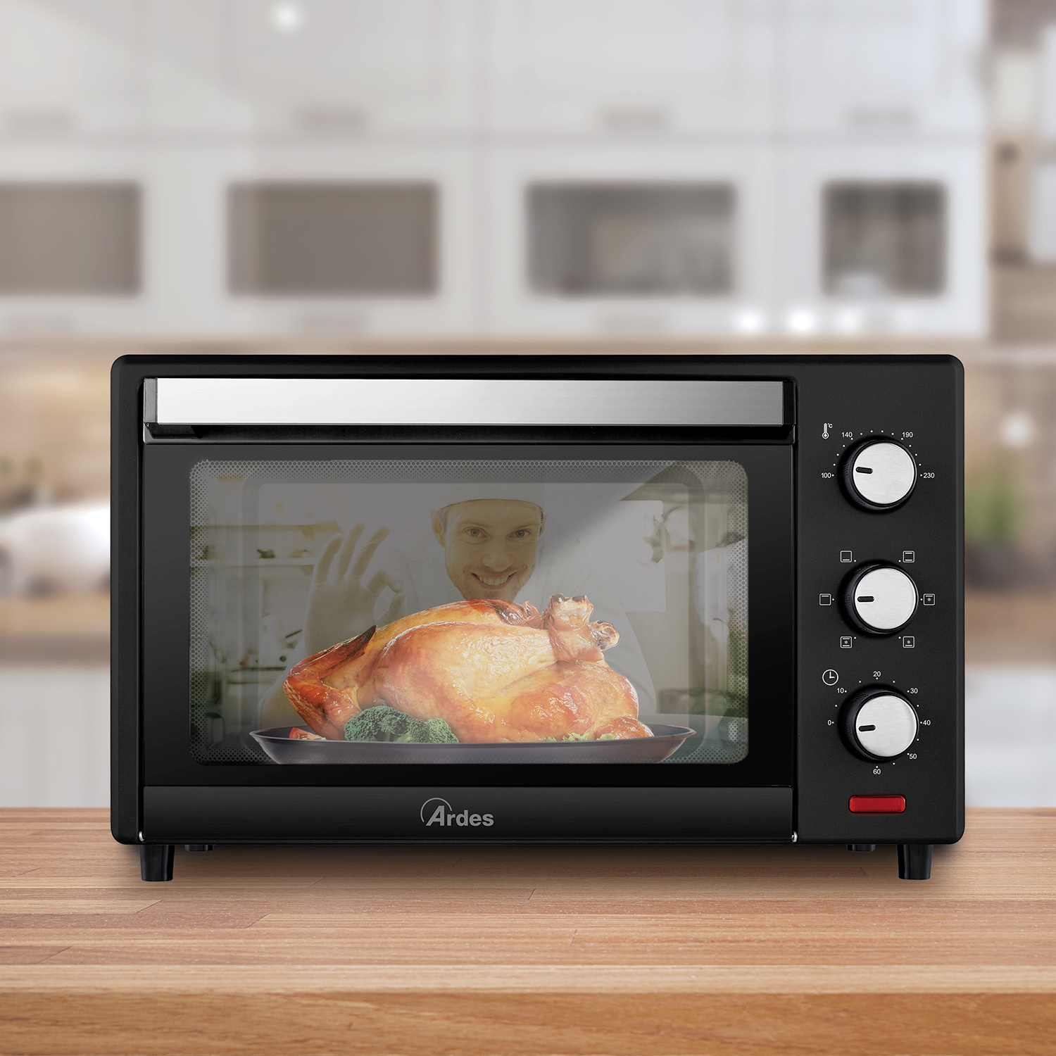 Un forno nero con un pollo cotto all'interno. Un cuoco è visibile nel riflesso.