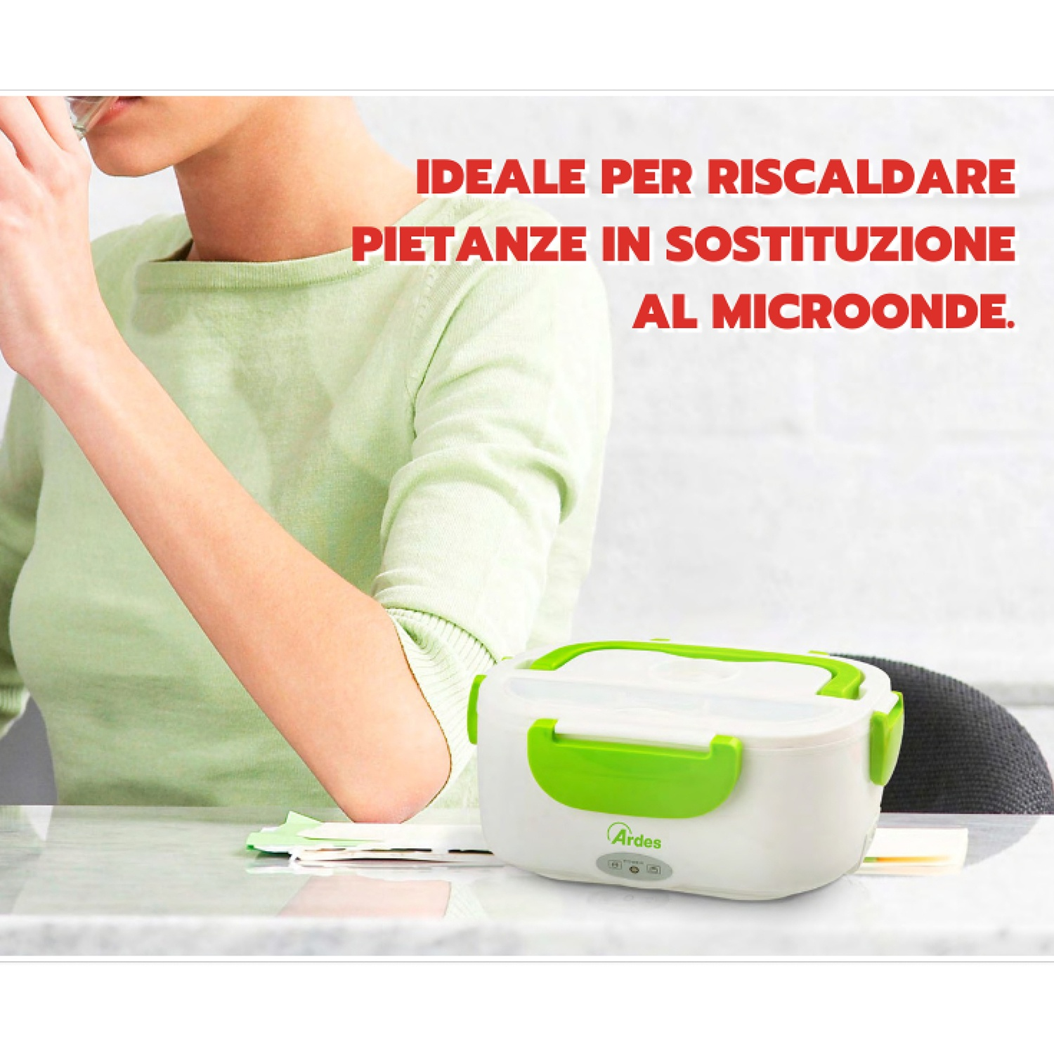 Una donna con una camicia verde è seduta a una scrivania. Un portapranzo bianco e verde è sulla scrivania.