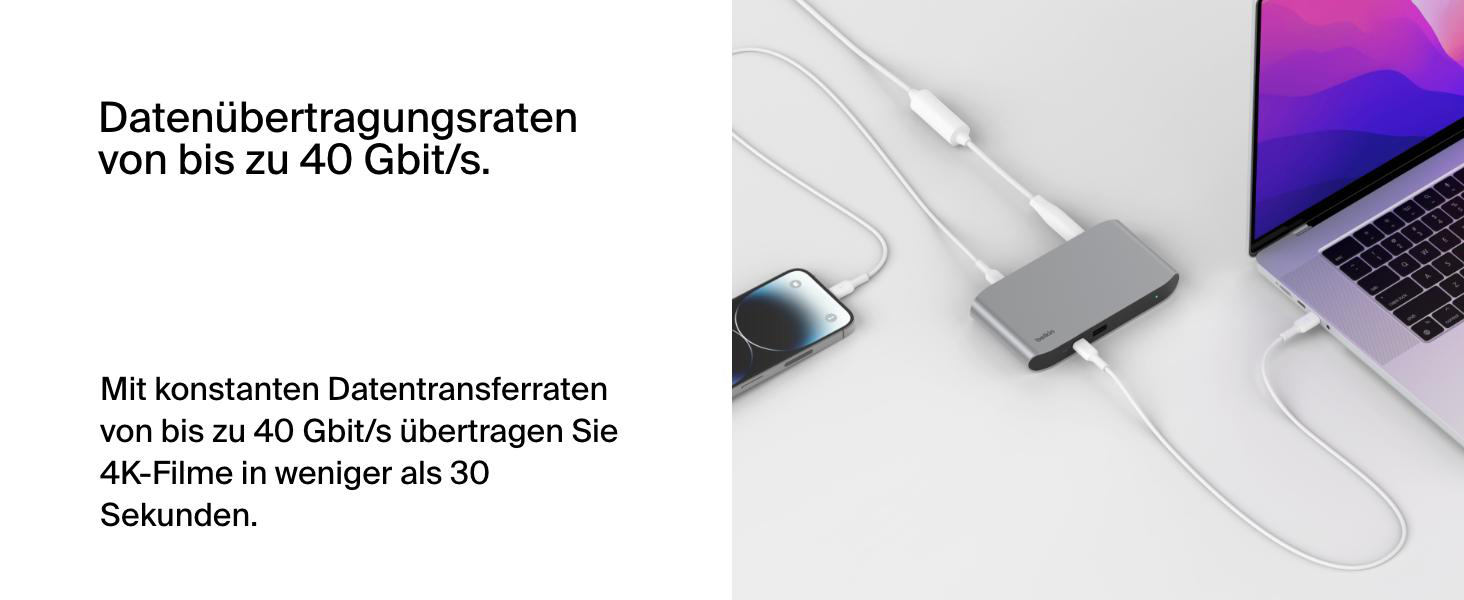 Laptop, Telefon und Hub mit weißen Kabeln auf weißem Hintergrund verbunden.