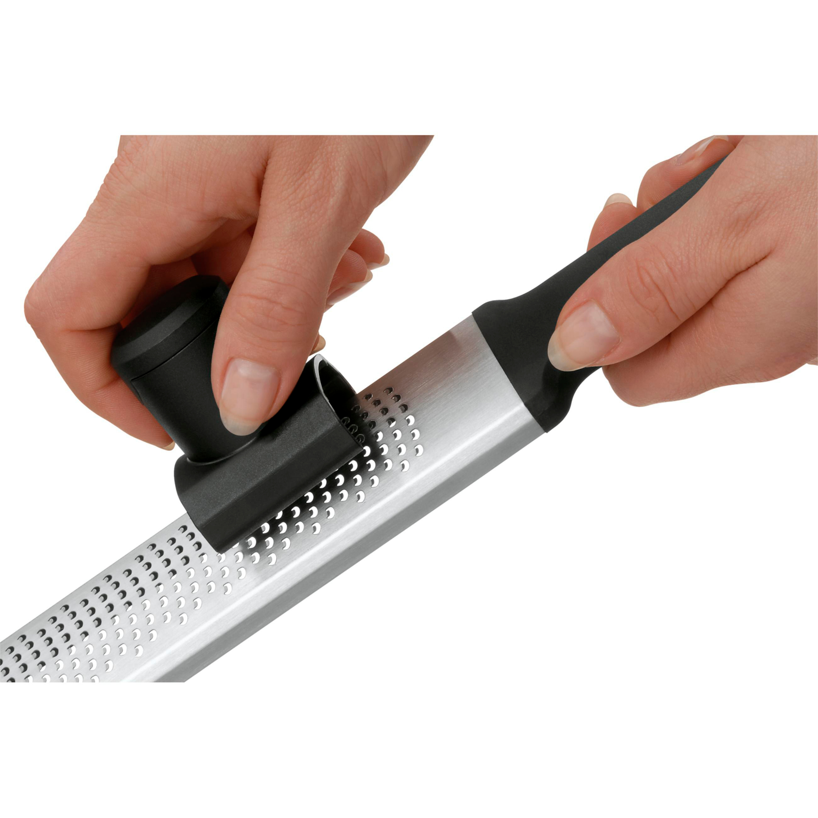 Hände halten eine Reibe mit schwarzem Griff. Weißer Hintergrund.