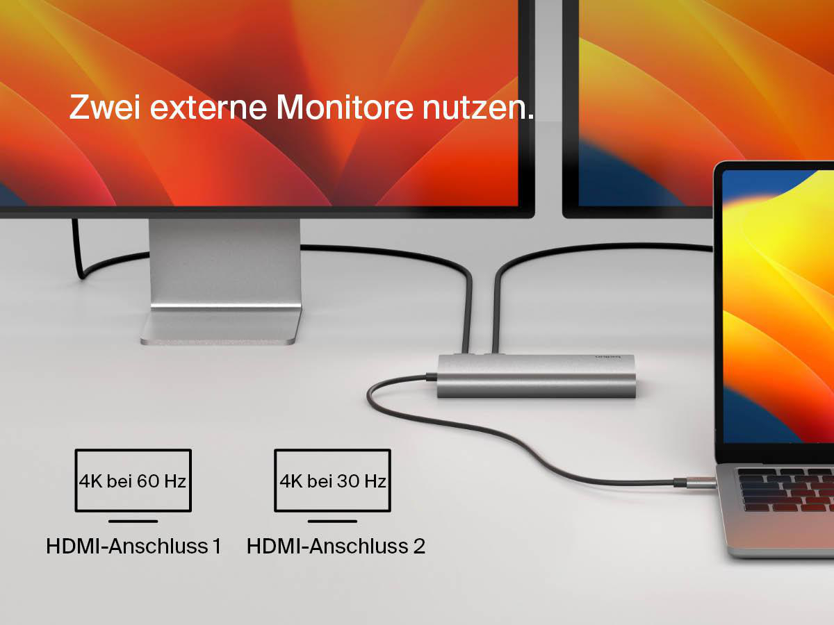 Zwei Computermonitore sind an einen silbernen Hub angeschlossen. Ein Laptop ist ebenfalls angeschlossen.