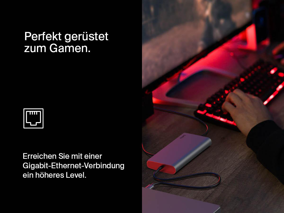 Eine Person benutzt eine Tastatur mit rotem Hintergrund. Ein silbernes Gerät mit rotem Ende ist im Bild.