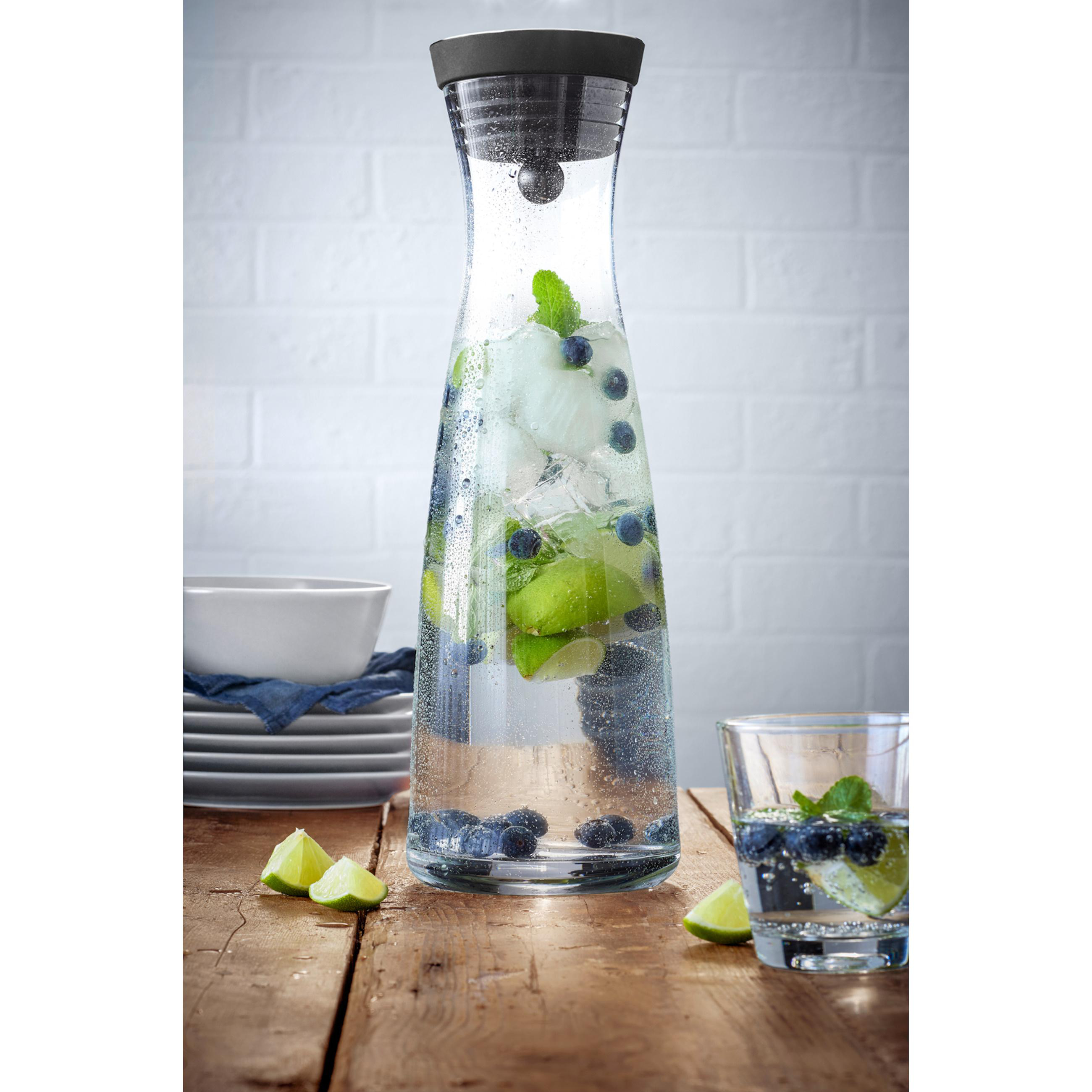 Glaskrug mit Eis, Blaubeeren und Limettenscheiben. Ein Glas mit demselben.