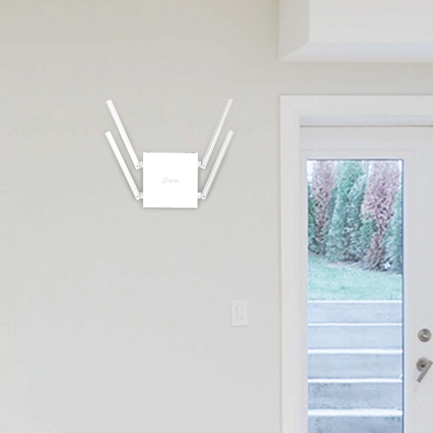 Router wifi TP-Link bianco montato su una parete bianca con una porta e dei gradini sullo sfondo.