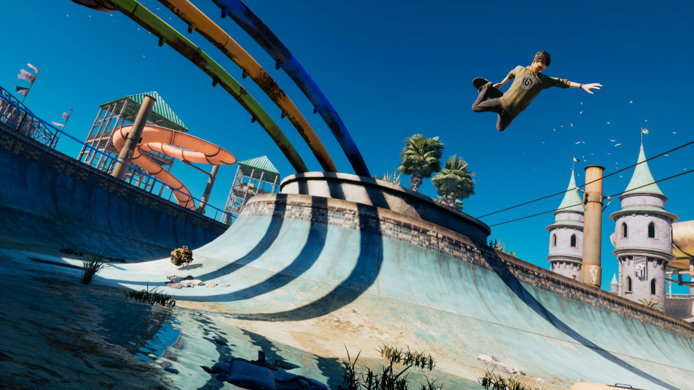 Een skateboarder in de lucht boven een waterpark-achtige structuur met levendige kleuren onder een blauwe lucht.