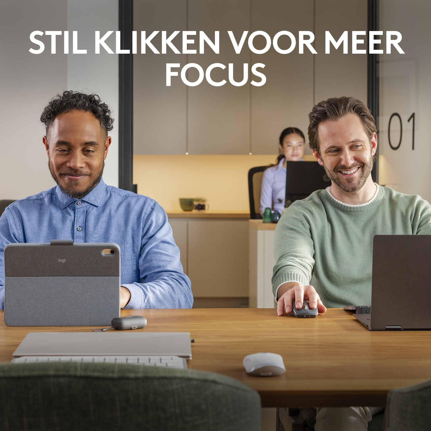 Twee mannen en een vrouw werken op hun laptops aan een houten tafel. Een muis op de voorgrond.