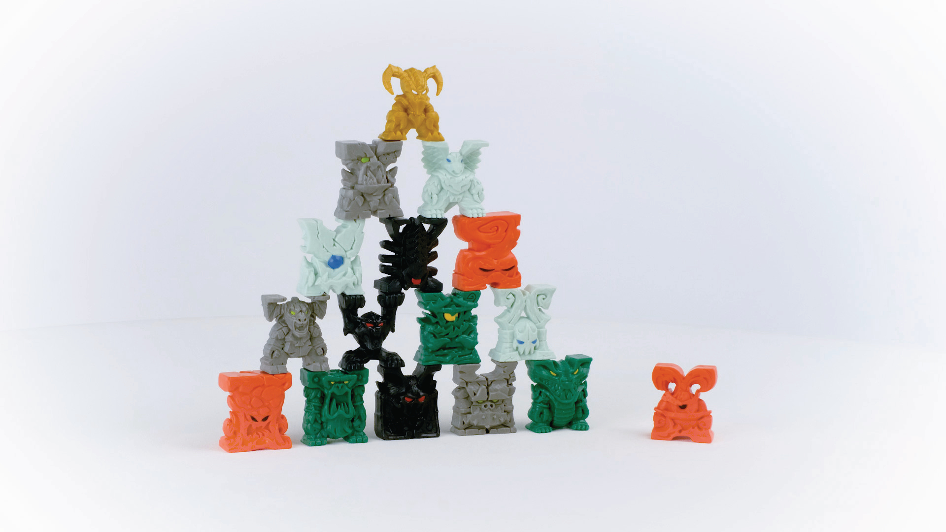 Eine Pyramide aus bunten Spielfiguren. Sie haben Gesichter und sehen aus wie kleine Statuen.