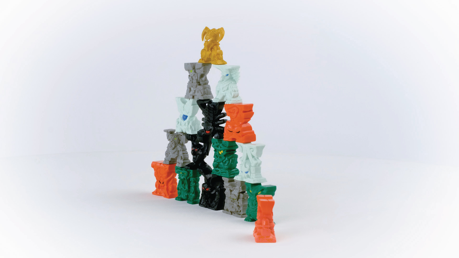 Bunte, gestapelte Spielzeugblöcke, die auf einer weißen Oberfläche pyramidenförmig angeordnet sind.